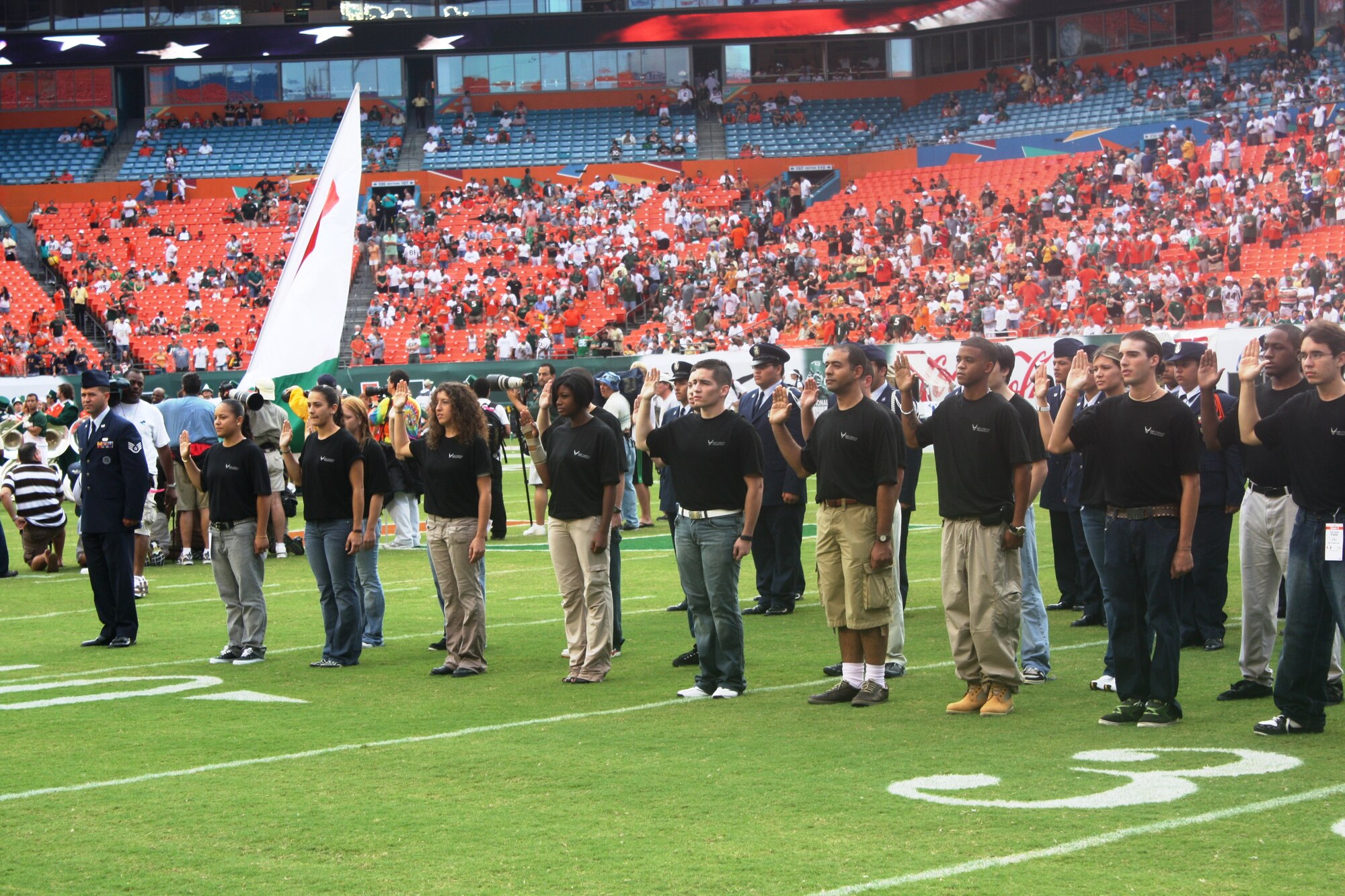 Twenty-two young men and women became members of the Air Force Reserve during a mass enlistment ceremony at Dolphins Stadium prior to the University of Miami Hurricanes football game on Oct. 11. The pre-game activities also featured a fly over by F-16’s assigned to the 93rd Fighter Squadron and playing of the National Anthem by Staff Sgt. Johnny Holiday, 482nd Security Forces Squadron.  The Hurricanes defeated the University of Central Florida 20-14. (U.S. Air Force photo/Master Sgt. Scott Soucie) 