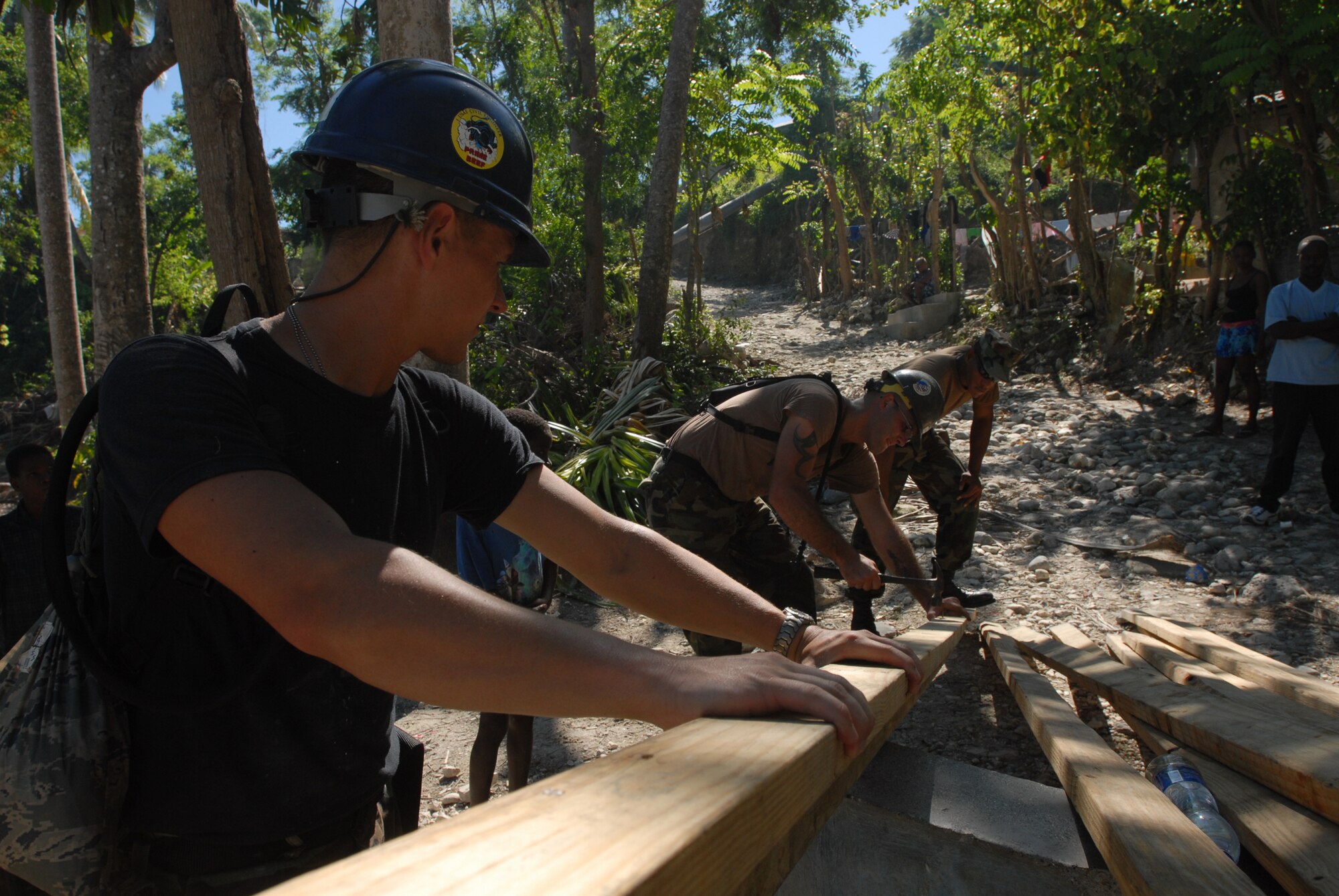BAINET, Haiti -- Airmen from Minot Air Force Base's 5th Civil Engineer Squadron Prime Base Engineer Emergency Force and Navy Seabees, currently embarked aboard USS Kearsarge (LHD 3) in support of Continuing Promise 2008, reconstruct a water pipeline that was destroyed in recent storms. CP 2008 is a collaborative effort between the United States and partner militaries, non-governmental organizations, and partner-nation support organizations to build strong partnerships that can be called upon in the event of a regional situation requiring cooperative solutions. (U.S. Navy photo by Mass ?Communication Specialist 2nd Class (AW/SW) Gina Wollman)