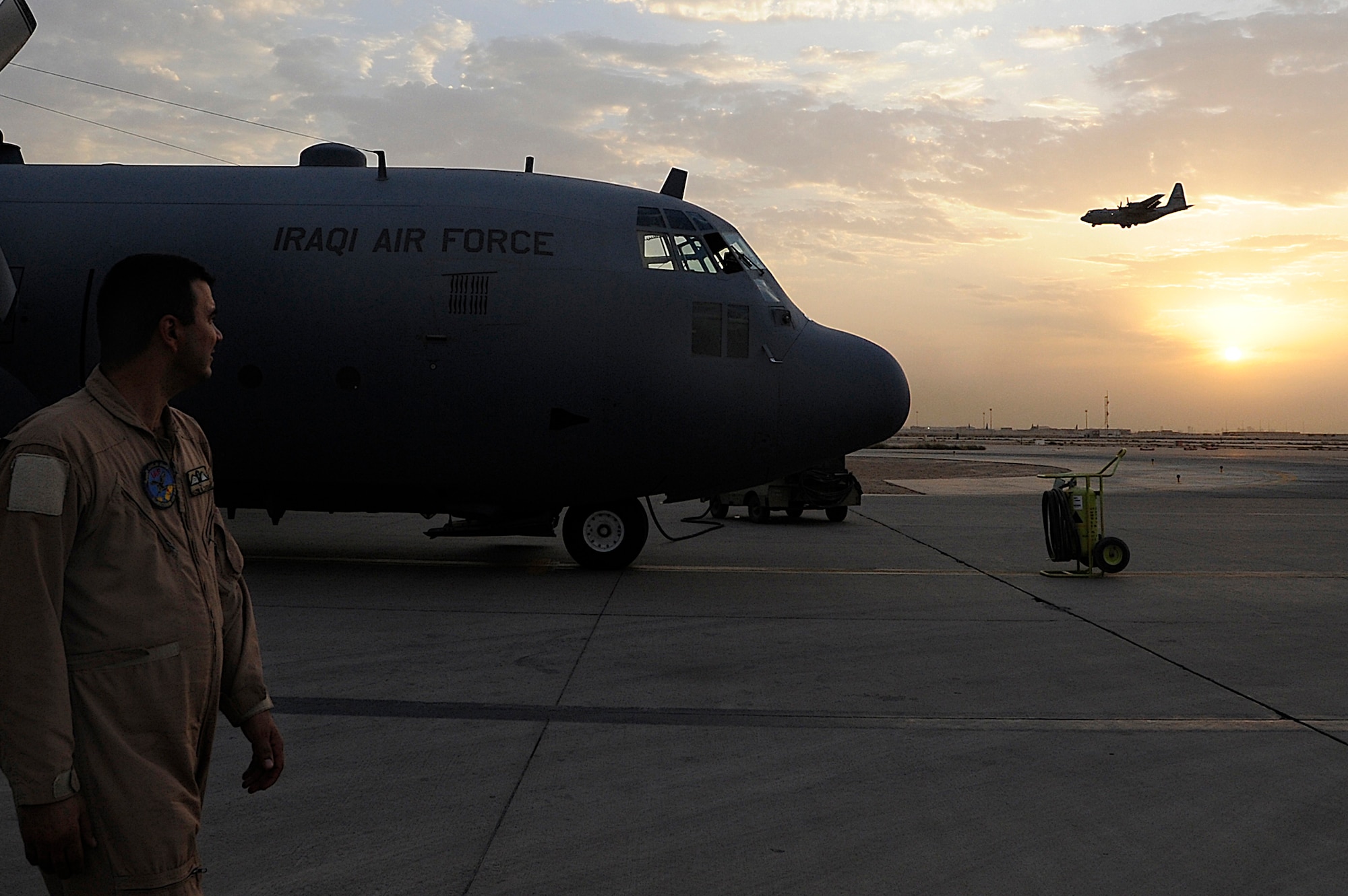 An Iraqi airman watches a C-130 land Oct. 11 at Joint Base Balad, Iraq. The airmen were on a cargo resupply mission with members of the U.S. Air Force 370th Air Expeditionary Advisory Squadron. They are assigned to 23rd Squadron, which operates three C-130s used for transporting troops, supplies and distinguished visitors. (U.S. Air Force photo/Airman 1st Class Jason Epley) 
