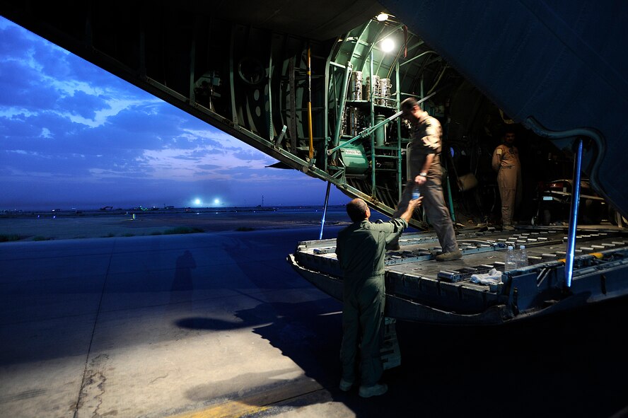 An Iraqi airman gives another airman a water bottle Oct. 11 at Joint Base Balad, Iraq. The Iraqi airmen were on a cargo resupply mission with members of the U.S. Air Force 370th Air Expeditionary Advisory Squadron, who operate C-130 aircraft used for transporting troops, supplies and distinguished visitors. (U.S. Air Force photo/Airman 1st Class Jason Epley) 