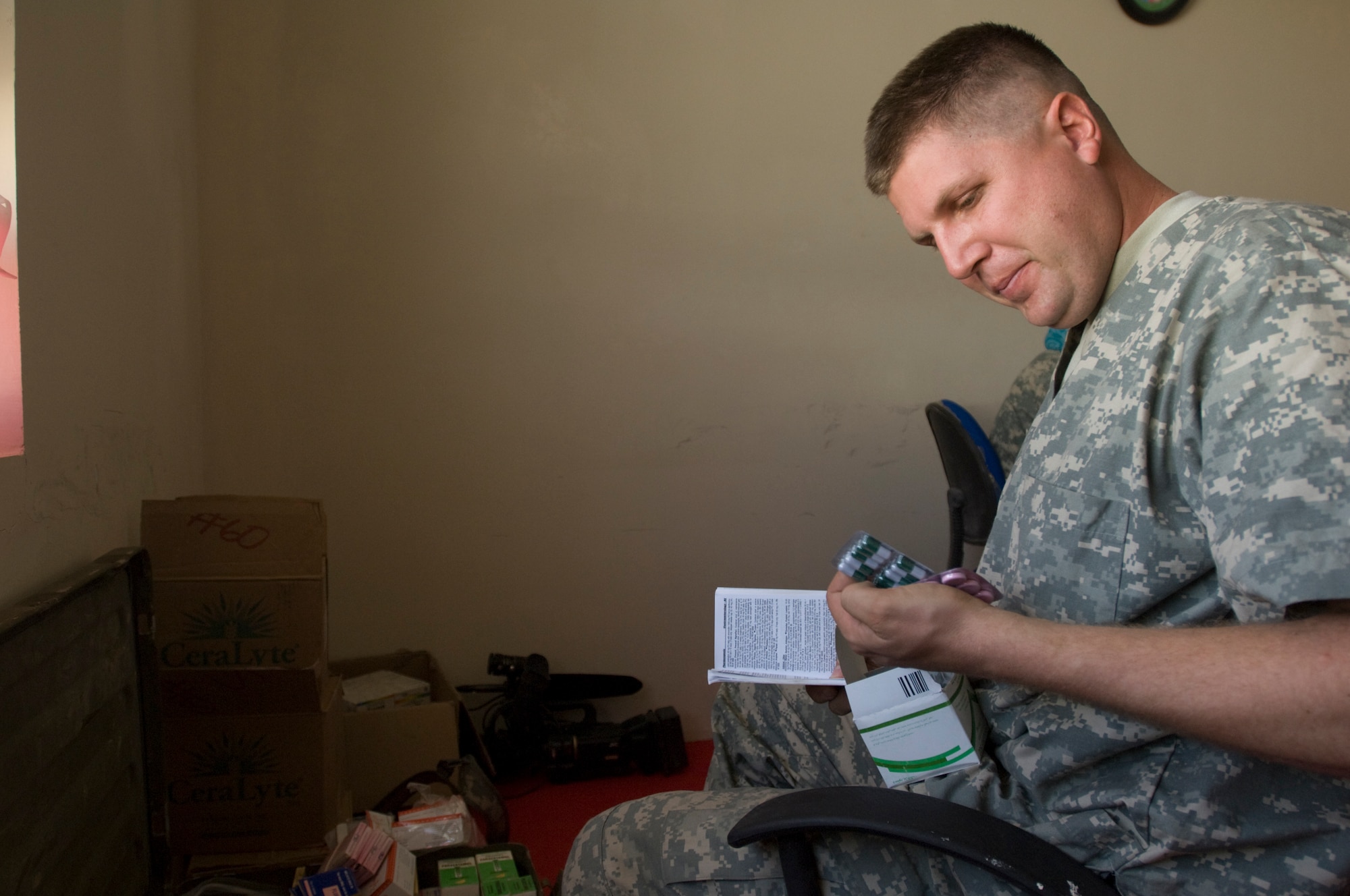 QALAT, Afghanistan -- Capt. (Dr.) James Arnold,  Zabul Provincial Reconstruction Team, researches a prescription to treat an Afghan woman's illness during a Woman's Village Medical Outreach visit. The Zabul PRT medics treated a variety of problems ranging from headaches due to dehydration and stomach aches caused by worms and unhealthy water. Dr. Arnold is a family practice doctor deployed to the PRT from Anderson Air Force Base, Guam.(U.S. Air Force photo/Master Sgt. Keith Brown)
