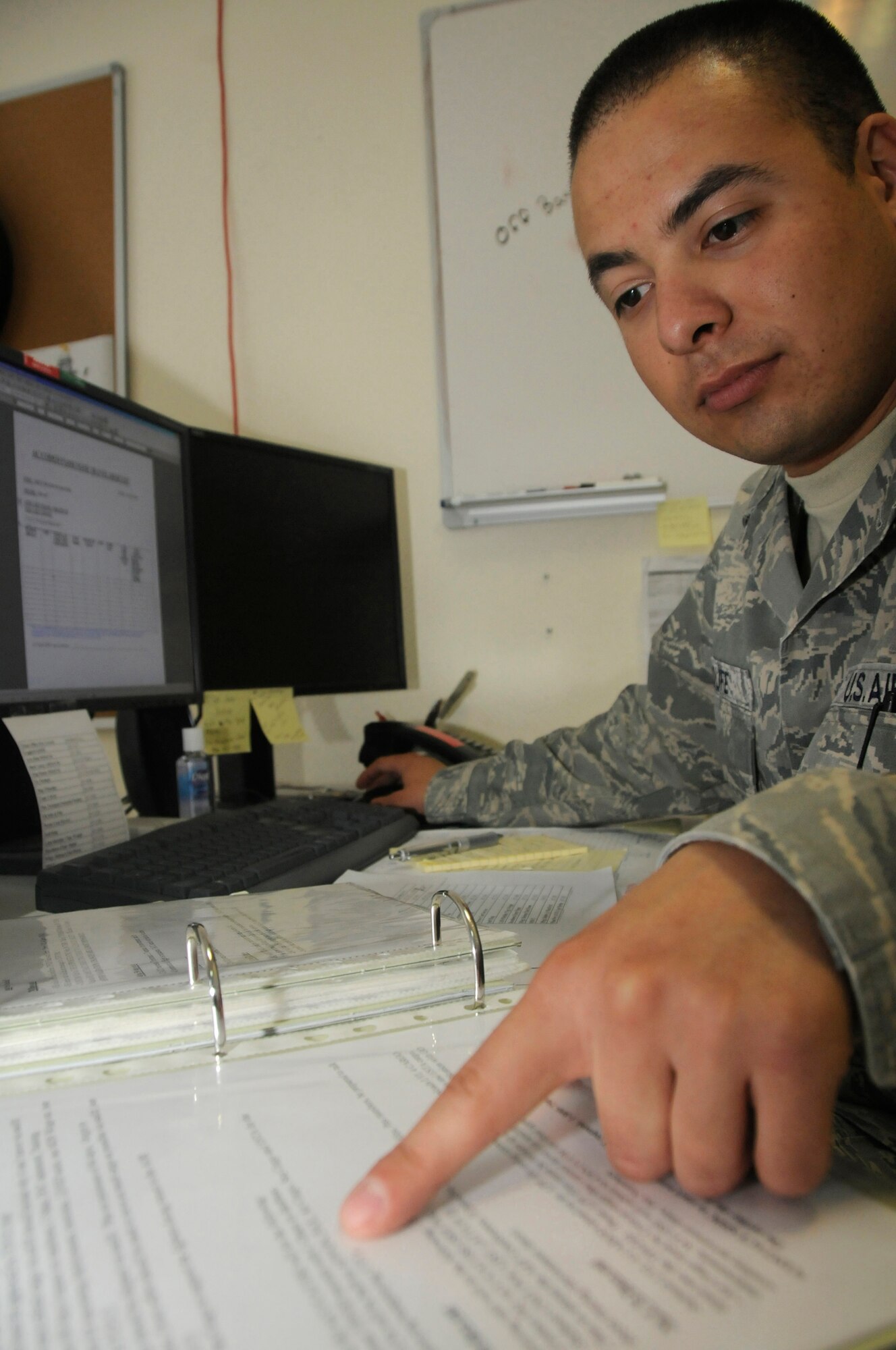Staff Sgt. Brandon Sroufe, unit deployment manager for the 379th Expeditionary Maintenance Group, refers to his UDM program book while requesting commercial airline tickets for redeploying personnel, October 13, 2008.  The unit deployment managers here are responsible for ensuring deploying and redeploying members have everything in place for a smooth transition into and out of this undisclosed location in Southwest Asia. Sergeant Sroufe, a native of Fort Wayne, Ind., is deployed from Royal Air Force Mildenhall, United Kingdom, in support of Operations Iraqi and Enduring Freedom and Joint Task Force-Horn of Africa. (U.S. Air Force photo by Staff Sgt. Darnell T. Cannady/Released)