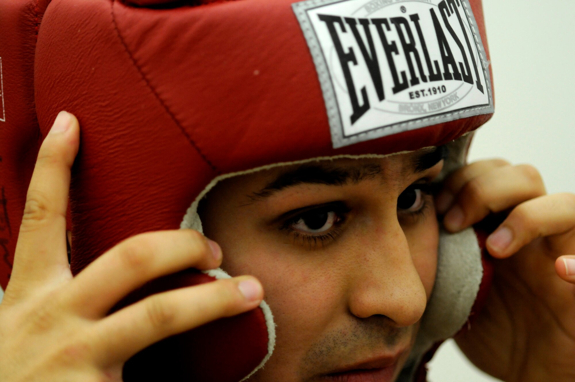 United States Army Pfc. Abel Ortegon, Aurvey Division, Shape, Belgium, secures his headgear as Spc. Ray Rodriquez, Dental Clinic, Shape, Belgium, helps prior to a boxing match, Vogelweh Air Base, Germany, Oct. 11, 2008. Vitali Frei, a German boxer from the Turngemeinde Worms Boxing Club, defeated Pfc. Ortegon. (U.S. Air Force photo by Staff Sgt. Sarayuth Pinthong)(Released)