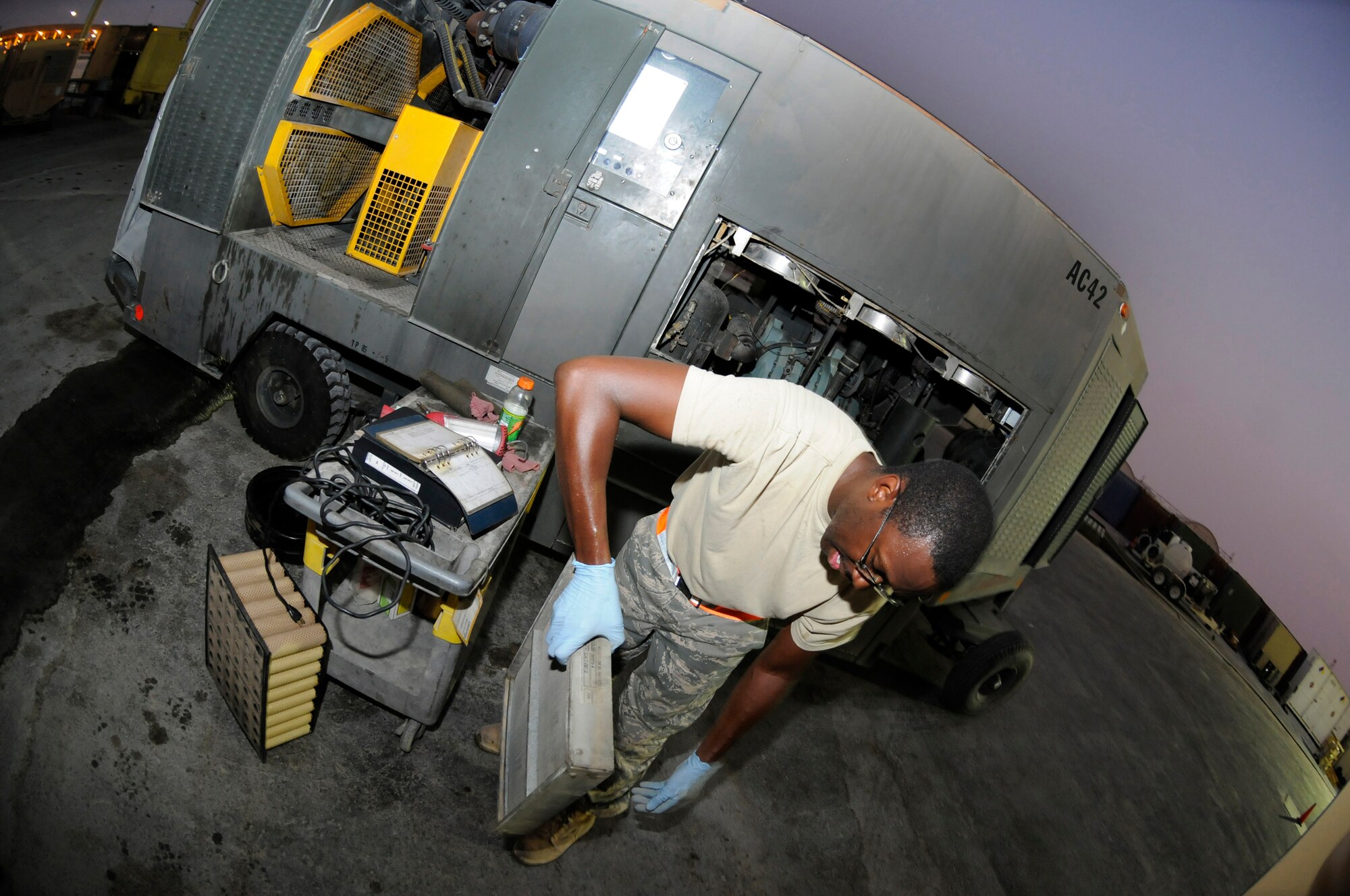 Senior Airman Scott Johnson, 379th Expeditionary Aircraft Maintenance Squadron, Aerospace Ground Equipment shop, inspects an air filter from an air conditioning/heating unit, October 13, 2008, at an undisclosed air base in Southwest Asia.  The air filters were pulled as part of a phase 2 inspection, which involves checking each system on the unit and changing all filters and fluids.  In the desert heat, air conditioning units are mission essential because without them aircraft components would overheat during pre-flight operation checks.  Airman Johnson, a native of Warner Robins, Ga., is deployed from Kadena Air Base, Japan, in support of Operations Iraqi and Enduring Freedom and Joint Task Force-Horn of Africa.  (U.S. Air Force photos by Tech. Sgt. Michael Boquette/Released)