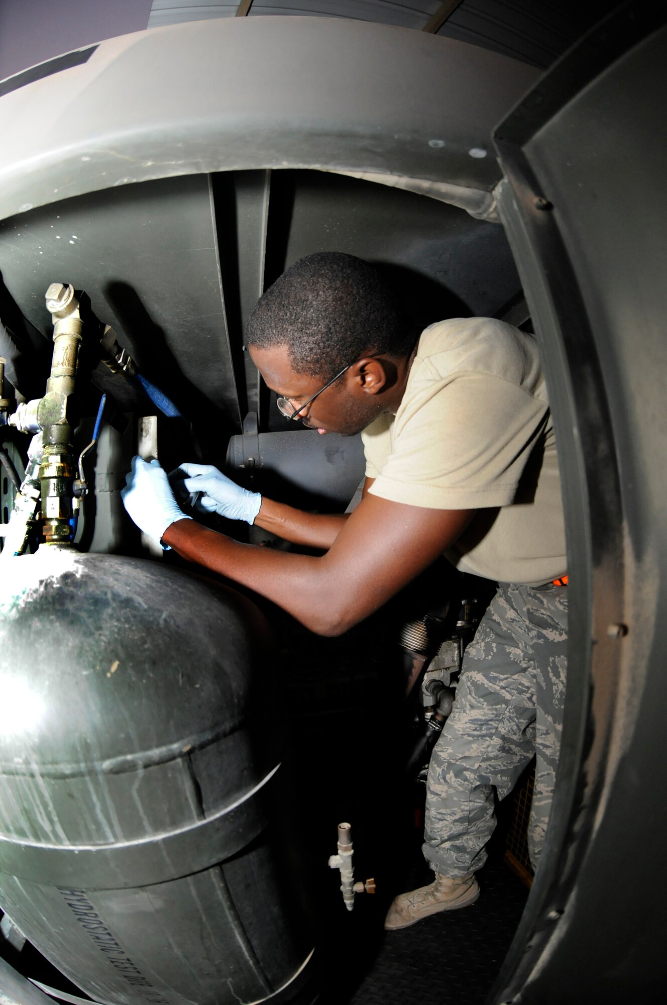 Senior Airman Scott Johnson, 379th Expeditionary Aircraft Maintenance Squadron, Aerospace Ground Equipment shop, climbs inside an air conditioning/heating unit in order to change air filters, October 13, 2008, at an undisclosed air base in Southwest Asia.  The air filters were pulled as part of a phase 2 inspection, which involves checking each system on the unit and changing all filters and fluids.  In the desert heat, air conditioning units are mission essential because without them aircraft components would overheat during pre-flight operation checks.  Airman Johnson, a native of Warner Robins, Ga., is deployed from Kadena Air Base, Japan, in support of Operations Iraqi and Enduring Freedom and Joint Task Force-Horn of Africa.  (U.S. Air Force photos by Tech. Sgt. Michael Boquette/Released)