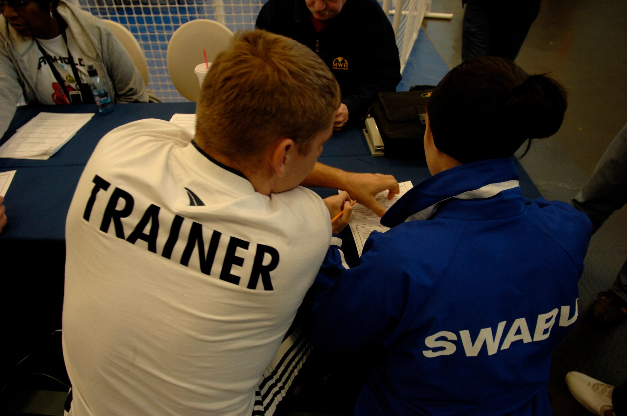 Markus Gotz, trainer from the Turngemeinde Worms Boxing Club, assists his female boxer, Janine Gertel, during registration before the boxing match, Vogelweh Air Base, Germany, Oct. 11, 2008. Gertel was the only female boxer that registered to compete allowing her to win the gold medal by default. (U.S. Air Force photo by Senior Airman Amber Bressler)(Released)
