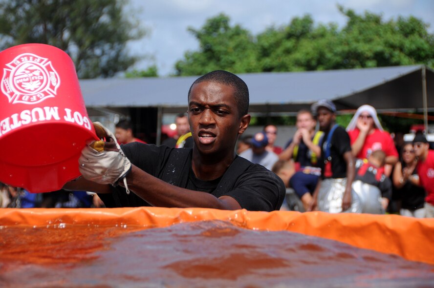 ANDERSEN AIR FORCE BASE, Guam - Airman 1st Class Devin Roberson dips his water pale in the pool during the Bucket Brigade at the 2008 Guam Fire Muster Competition at Paseo Park Oct. 12. The competition is intended to boost morale and build better working relationships with all fire departments on the island. (U.S. Air Force photo by Airman 1st Class Courtney Witt)