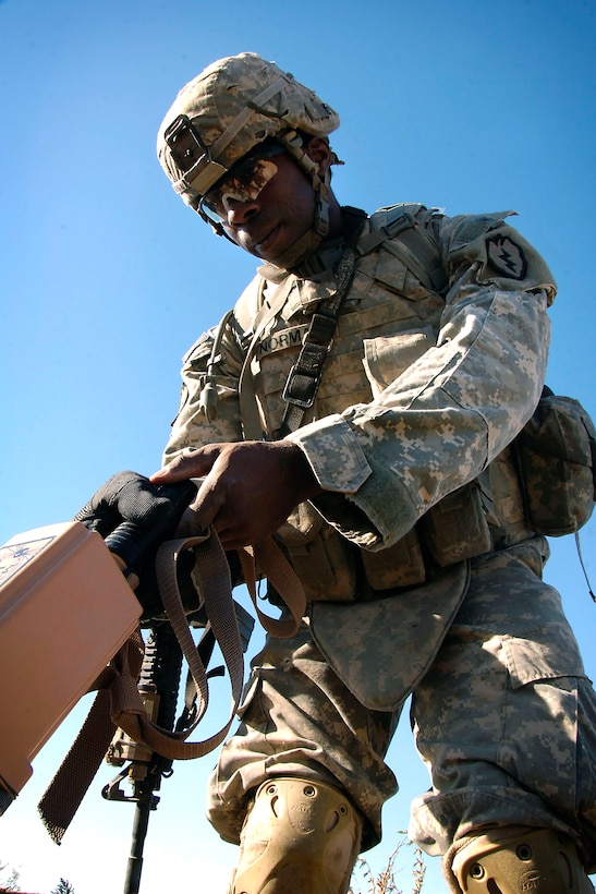 U.S. Army Spc. Binta Norman scans the ground for hidden weapons using a ...