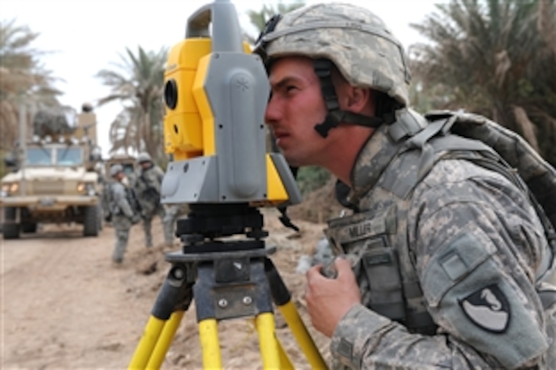 U.S. Army Spc. Casey Miller looks through surveyors theodolite equipment in the Qubah Village, Iraq, Oct. 12, 2008. Miller is assigned to the 63rd Engineer Company, which is part of a team that clears palm trees and roads in the Iraqi village. 