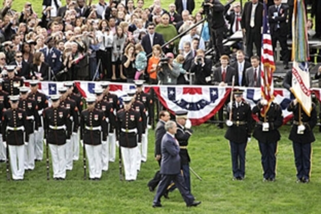President George W. Bush and Italian Prime Minister Silvio Berlusconi review the troops during welcoming festivities, Oct. 13, 2008, on the South Lawn of the White House. Bush lauded Italian forces for their help in fighting the war on terror.
