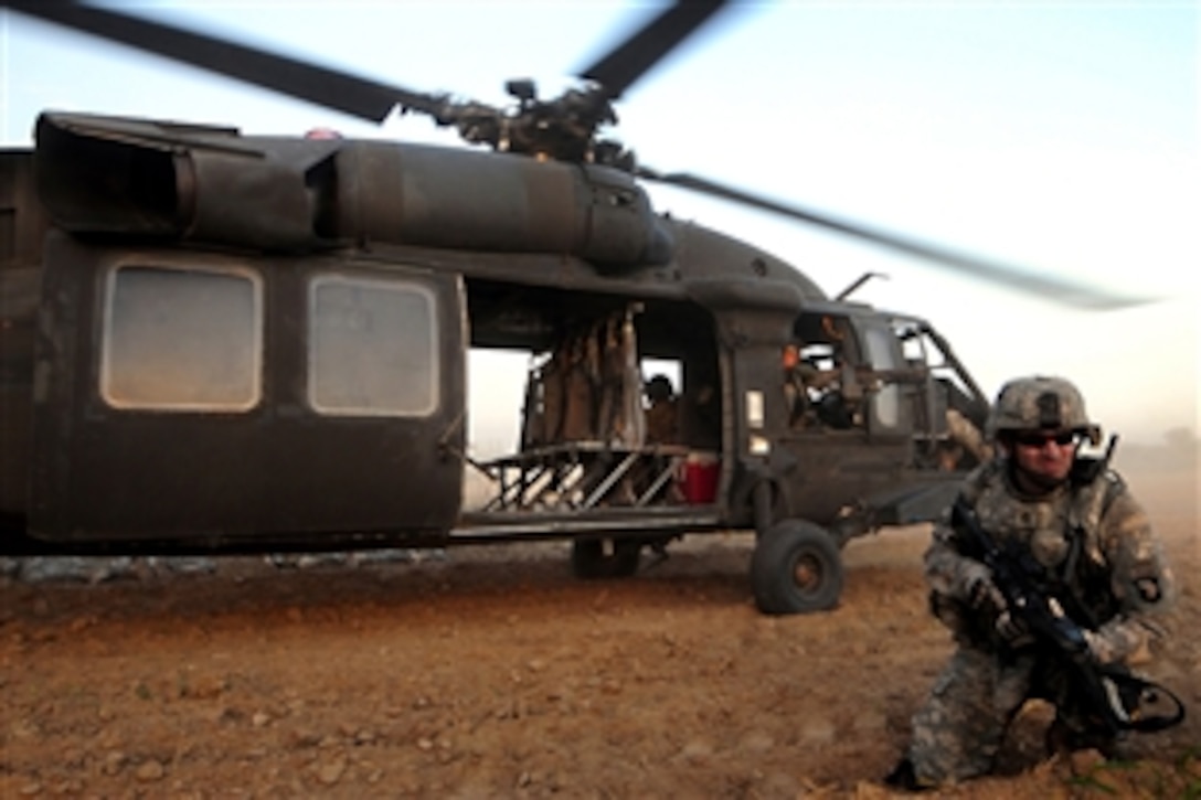 An U.S. Army soldier pulls security near a UH-60 Black Hawk helicopter during an air assault mission onto the banks of the Tigris River in Bayji, Iraq, Oct. 14, 2008. “The soldier is assigned to the 101st Airborne Division's 1st Battalion, 327th Infantry Regiment.