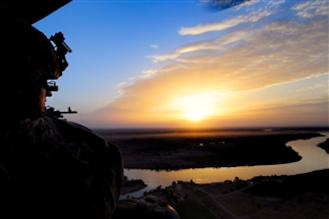 A U.S. soldier aboard a UH-60 Black Hawk helicopter flies over the banks of the Tigris River during an air-assault mission in Bayji, Iraq, Oct. 14, 2008. The soldier is assigned to the 101st Airborne Division's 1st Battalion, 327th Infantry Regiment. U.S. and Iraqi soldiers conducted Operation Deadbluff to reduce the number of enemy weapons caches in the area. 