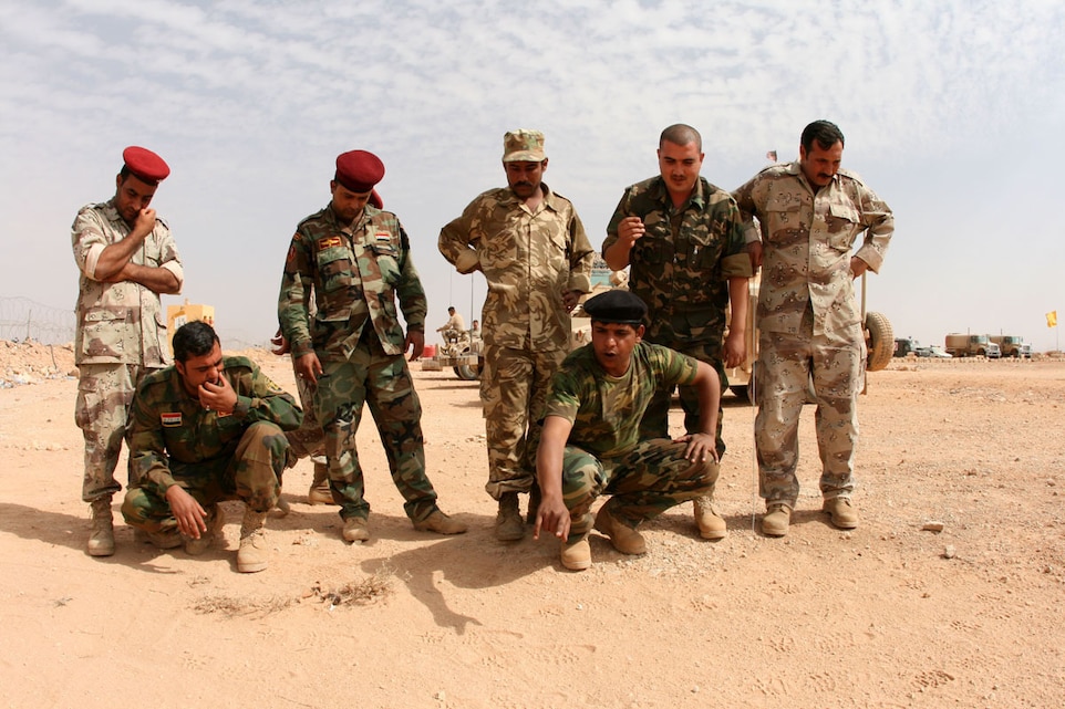 Malek Altameemy (front, right), 22, a native of al-Kut and member of the Desert Wolves, an Iraqi border-enforcement battalion, leads his team in a sign cutting and tracking exercise Oct. 14 to identify human footprints in the sand.  The exercise, facilitated by Marines from the Border Transition Team at Trebil, was designed to enable the students to teach future class to their Iraqi peers, located at remote outposts strung out along Iraq's border with the Jordan. ::r::::n::