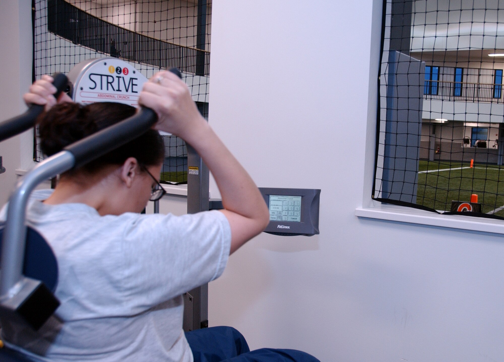Airman 1st Class Jamie Catham works her abdominal muscles in the newest part of the Baker Field House fitness center Oct. 13, 2008 at Eielson Air Force Base, Alaska. New exercise machines surround the indoor field and track to maximize space at the fitness center. (U.S. Air Force photo by Airman Laura Max)