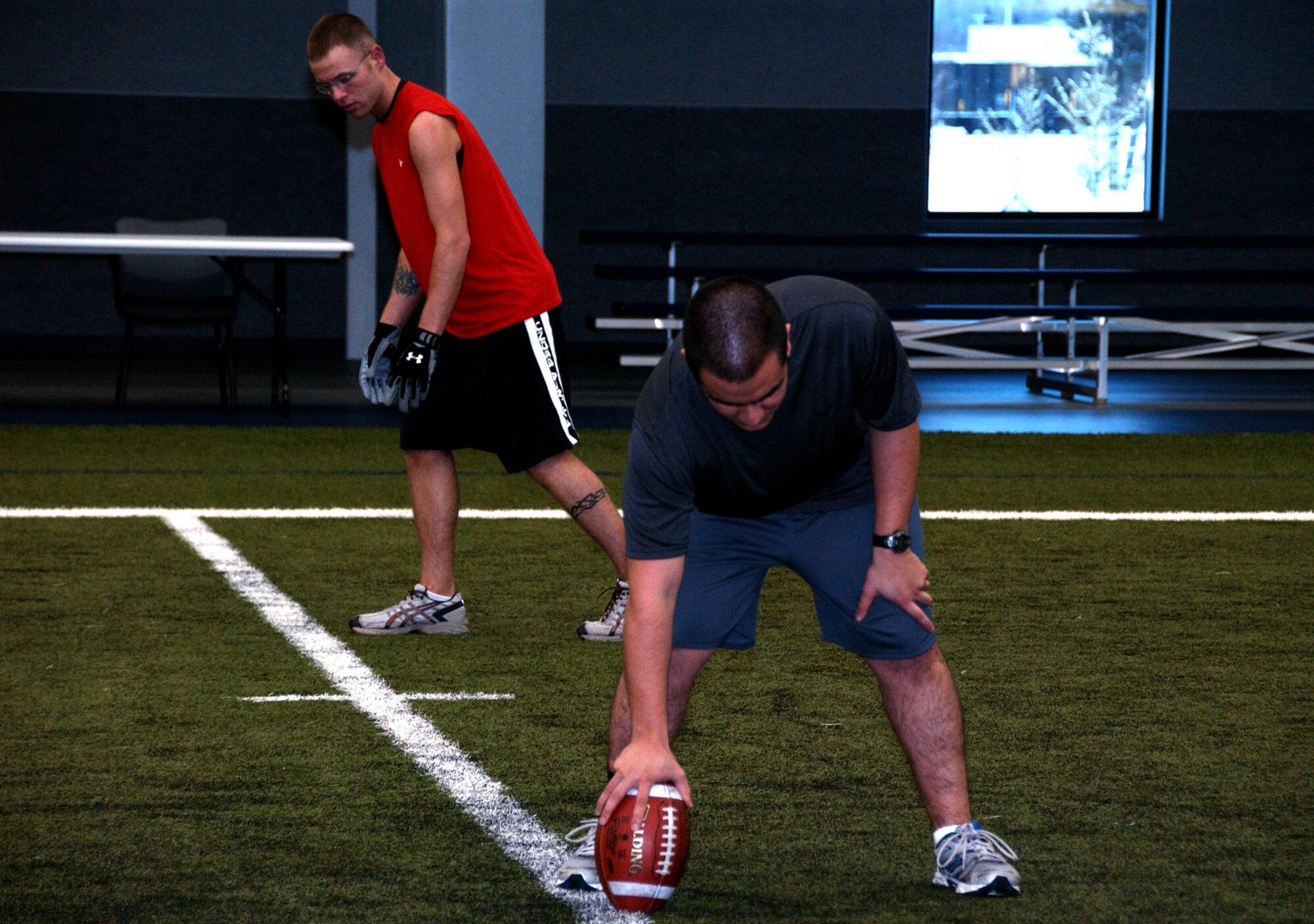 Senior Airman Brandon Johnson and 2nd Lt. Daniel Mota get ready to play football on the Baker Field House fitness center's indoor field Oct. 13, 2008 at Eielson Air Force Base, Alaska. The new indoor field was added to the center so Airman can play year round to boost morale through the cold winter months. (U.S. Air Force photo by Airman Laura Max)