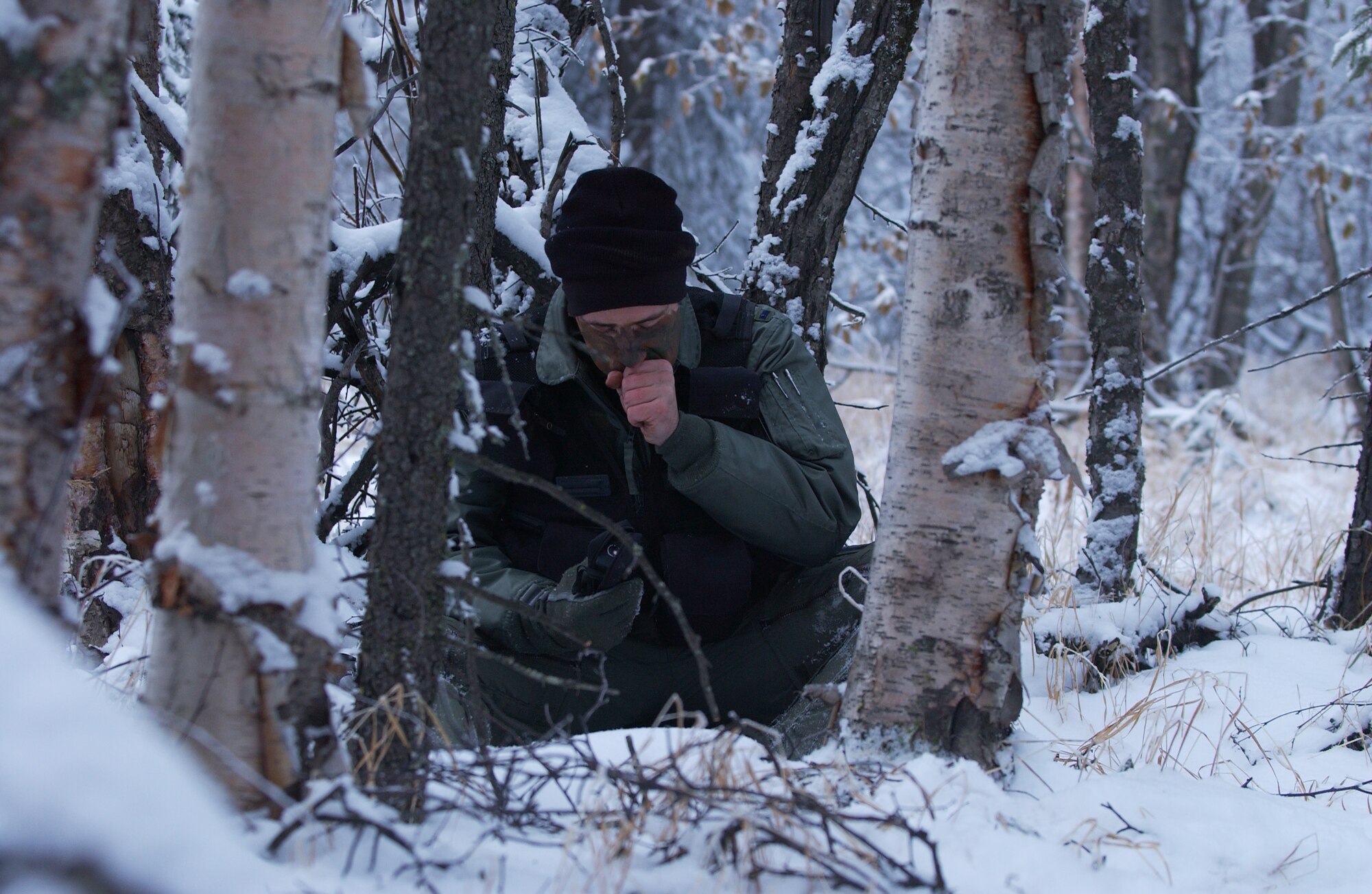 1st Lt. Matthew Feeman, 80th Fighter Squadron, Kunsan Air Base, Korea stops and rests while trying warm up his hand in below freezing conditions as he navigates through the woods to a safe location to get extracted during RED FLAG-Alaska 09-1 Oct. 14, 2008, at Eielson Air Force Base, Alaska. Lieutenant Feeman is playing the role of a pilot who was shot down behind enemy lines and he must now survive, evade, resist and escape to successfully complete the training mission.  (U.S. Air Force photo/Senior Airman Jonathan Snyder)
