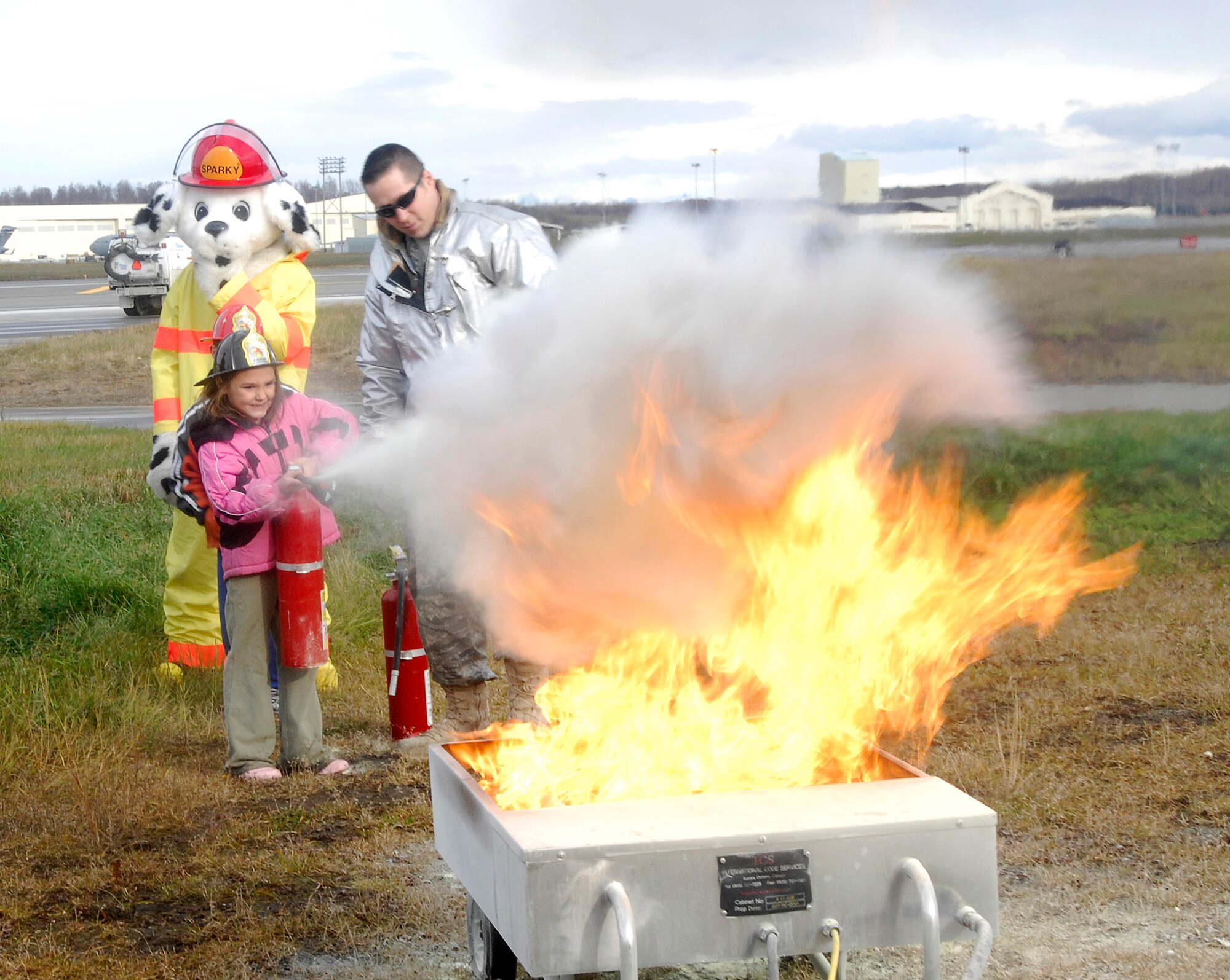 ELMENDORF AIR FORCE BASE, Alaska -- Staff Sgt. James Shultz teaches Abby Stegemoller how to properly use a fire extinguisher. A portable fire extinguisher can save lives and property by putting out a small fire or containing it until the fire department arrives. (U.S. Air Force photo/Airman 1st Class Kristin High)