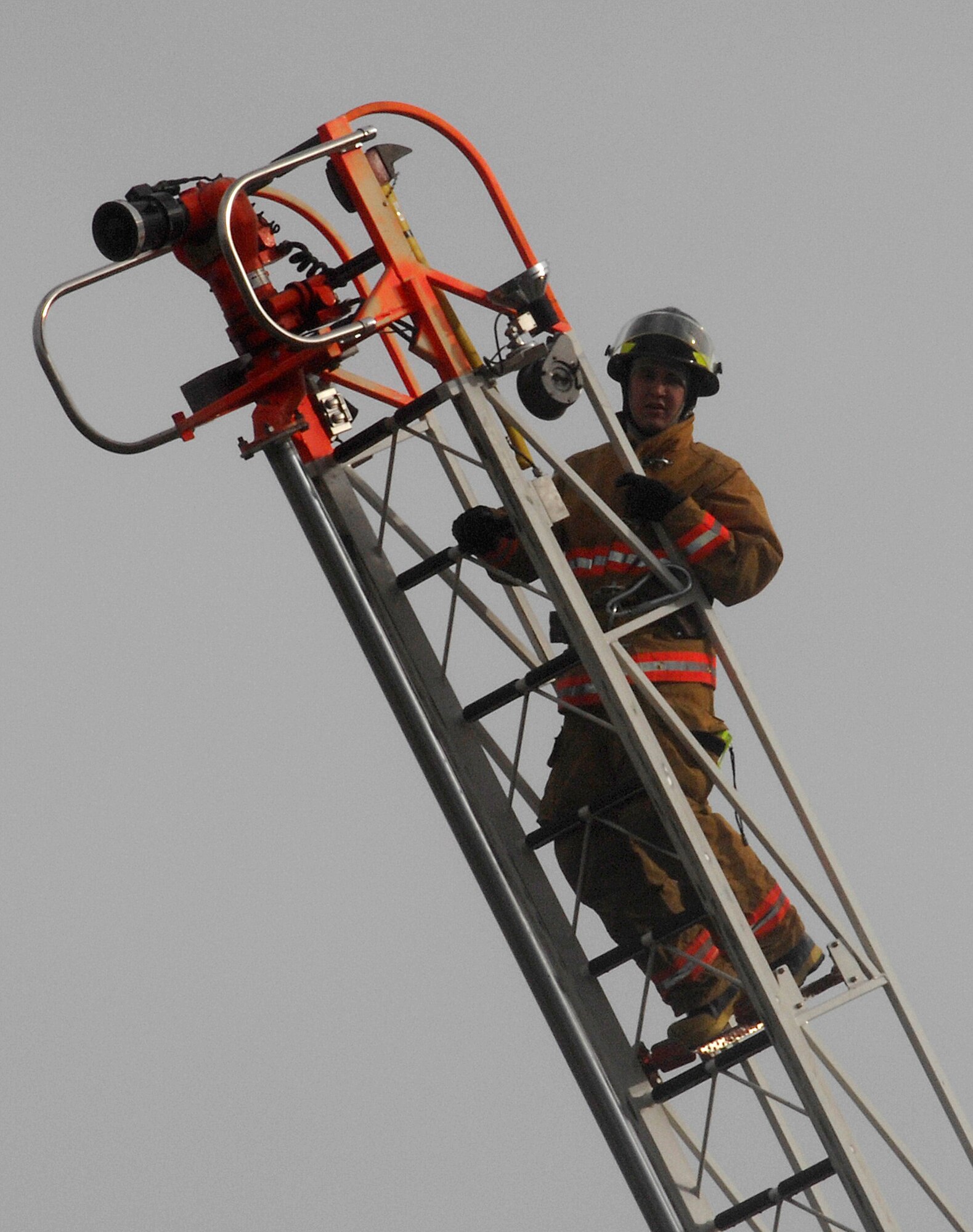 ELMENDORF AIR FORCE BASE, Alaska -- Airman Ryan Daniels, 3rd Civil Engineer Squadron Fire Protection Flight, demonstrates a ladder climb during the open house at Fire Station One Oct. 11. Fire can spread rapidly through your home, leaving you as little as two minutes to escape safely once the alarm sounds. Your ability to get out depends on advance warning from smoke alarms and advance planning. (U.S. Air Force photo/Airman 1st Class Kristin High)