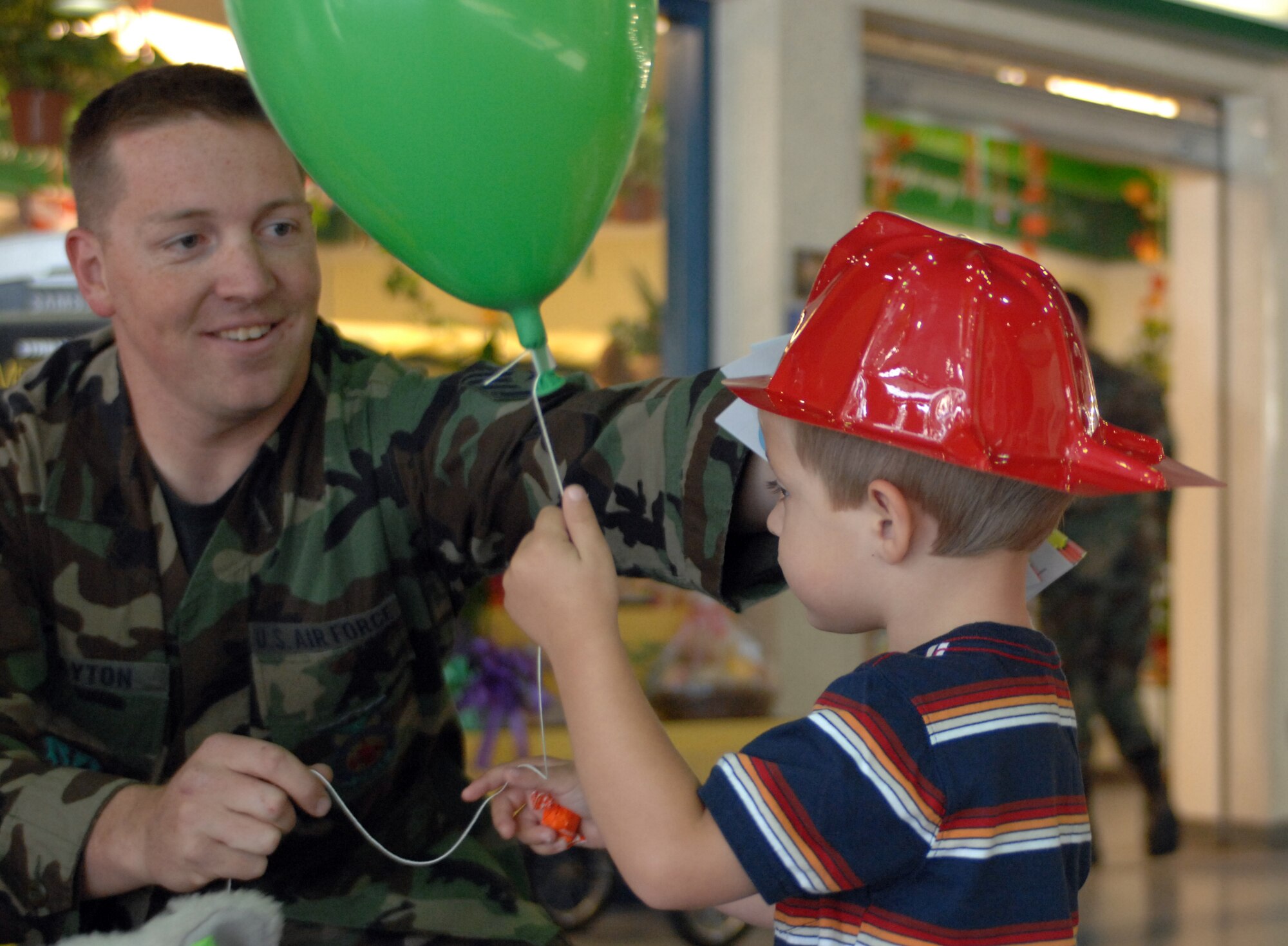 MOUNTAIN HOME AIR FORCE BASE, Idaho - Staff Sgt. Brian Layton, 366th Civil Engineer Squadron fire emergency services flight, places a toy fireman hat on Garrett Adams, 2, at the Mountain Home Air Force Base base exchange Sept. 7. The base fire department has forces with the National Fire Protection Association to remind Gunfighters of fire prevention techniques. (U.S. Air Force photo/ Airman 1st Class Ashley Tank)