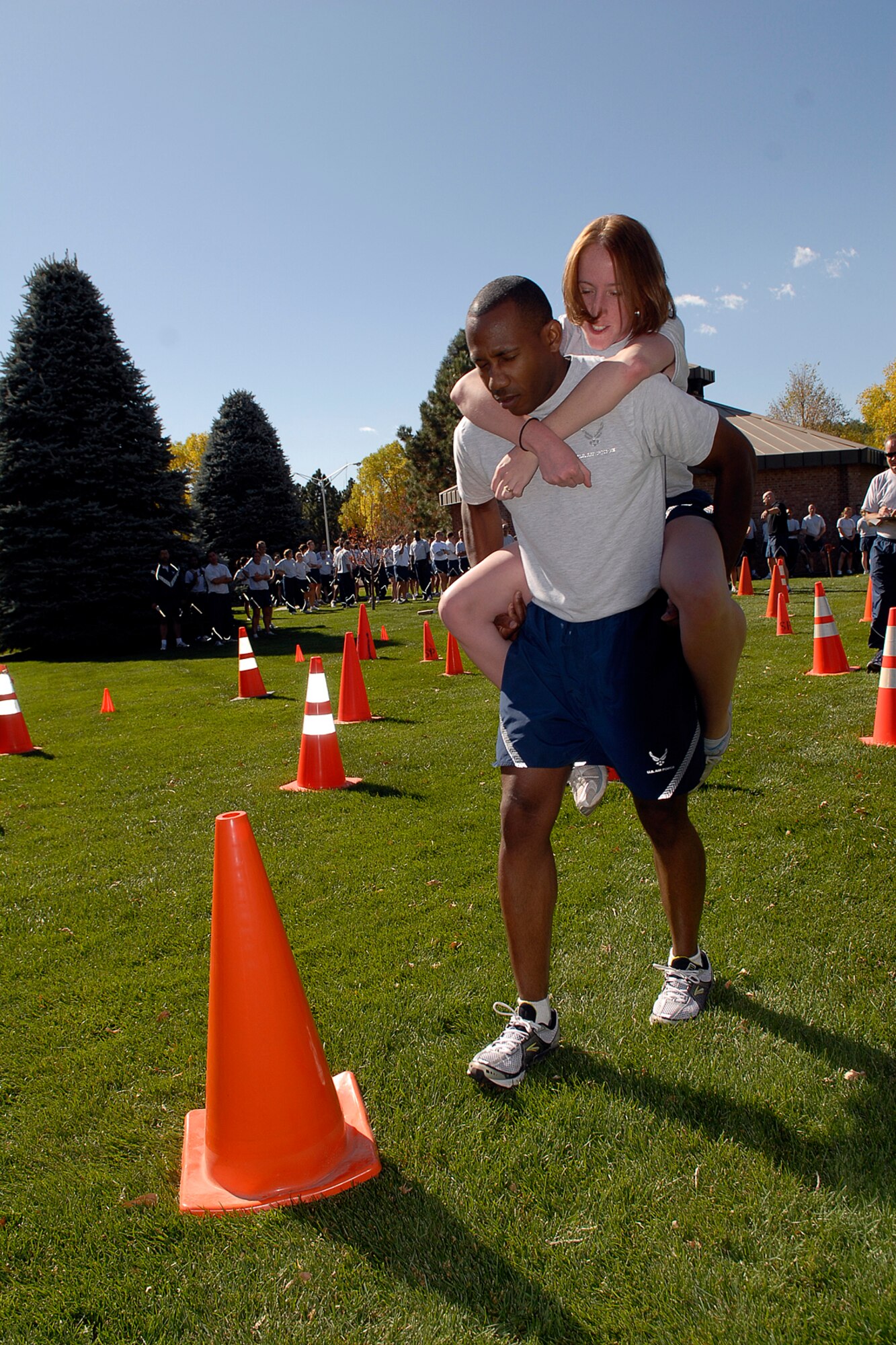 From the 21st Comptroller Squadron, Senior Airman Jessica Gillis catches a ride on the back of Seniorr Airman Larry Gordon during the Mine Field segment of Wingman’s Day at Peterson AFB on Oct. 10.  The Air Force established the Wingman program to encourage Airmen and their families to look out for each other and to intervene when signs of stress are observed. It's a promise, a pledge, a commitment between Airmen. (Air Force photo/Rob Bussard)