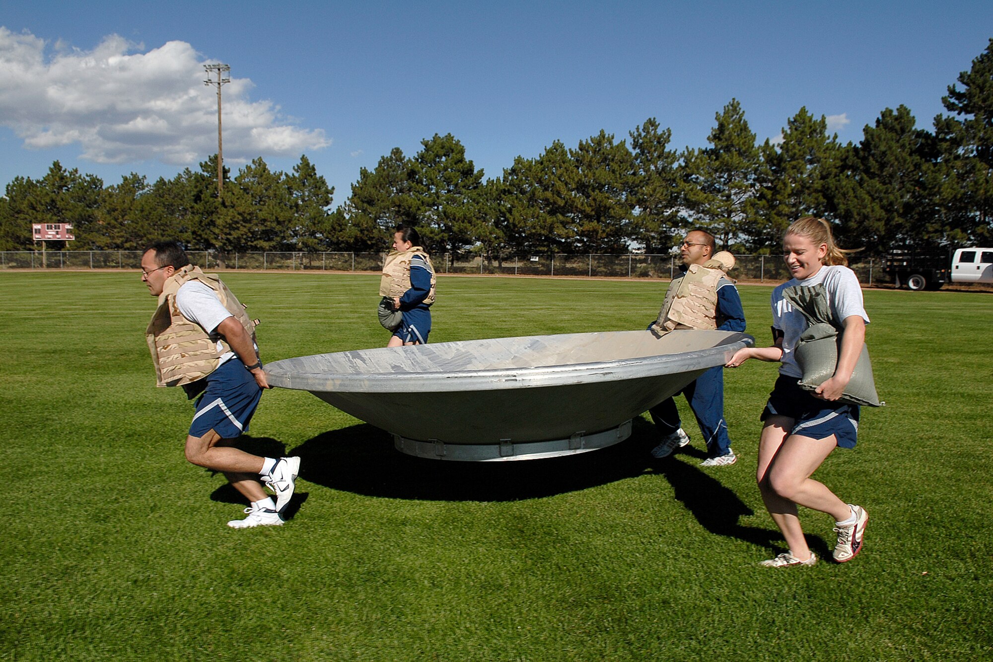 Team members of the 21st Medical Support Squadron run towards the finish line during the Pile Move during the Oct.10 Wingman Day at Peterson AFB, where objects of varying weight and size must be transported by team members. Each team member can only be used once, forcing teams to pre-plan their race for the best time. The Air Force established the Wingman program to encourage Airmen and their families to look out for each other and to intervene when signs of stress are observed. It's a promise, a pledge, a commitment between Airmen. (Air Force photo/Rob Bussard)