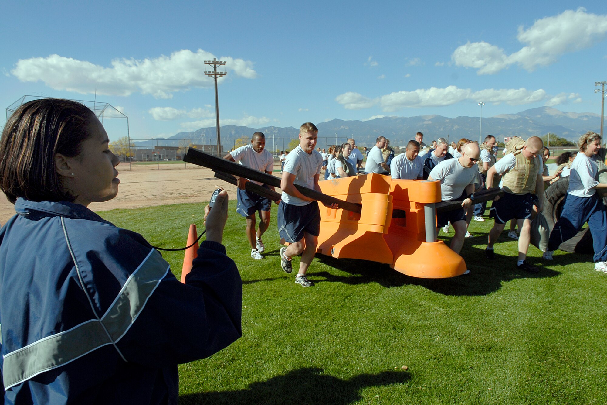 Staff Sgt. Tonya Patton, 21st Medical Operations Squadron, times the team members of the 21st Comptroller Suadron during the Pile Move portion of Wingman’s Day, held at Peterson AFB on Oct. 10. In the Pile Move, objects of varying weight and size must be transported by team members. Each team member can only be used once, forcing teams to pre-plan their race for the best time. The Air Force established the Wingman program to encourage Airmen and their families to look out for each other and to intervene when signs of stress are observed. It's a promise, a pledge, a commitment between Airmen. (Air Force photo/Rob Bussard)