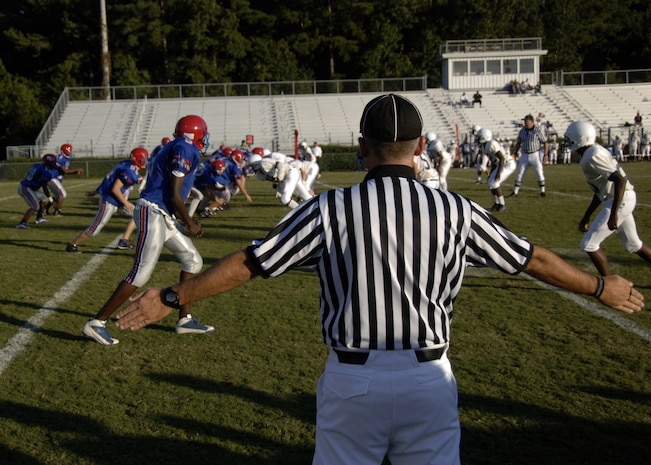 Randall Edwards signals that Fort Dorchester High School is wide out on the line of scrimmage during the Colleton County High School and Fort Dorchester High School freshman game in North Charleston, S.C., Oct. 2. The officiating crew is made up of Airmen or former Airmen who give back to the community through officiating high school, middle school and recreation department football games. Edwards is a master sergeant with the 437th Aerial Port Squadron at Charleston AFB. (U.S. Air Force photo/Airman 1st Class Timothy Taylor)