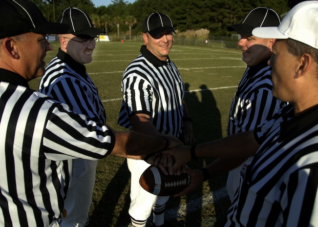 From left to right, football officials Randall Edwards, Sean Houlihan, Ed Ebersole, Scott Vendrely and Rocky Huggins review last-minute assignments before the Colleton County High School and Fort Dorchester High School freshman game in North Charleston, S.C., Oct. 2. The five-man crew is made uip of Airmen or former Airmen who give back to the community through officiating high school football games. (U.S. Air Force photo/Airman 1st Class Timothy Taylor)