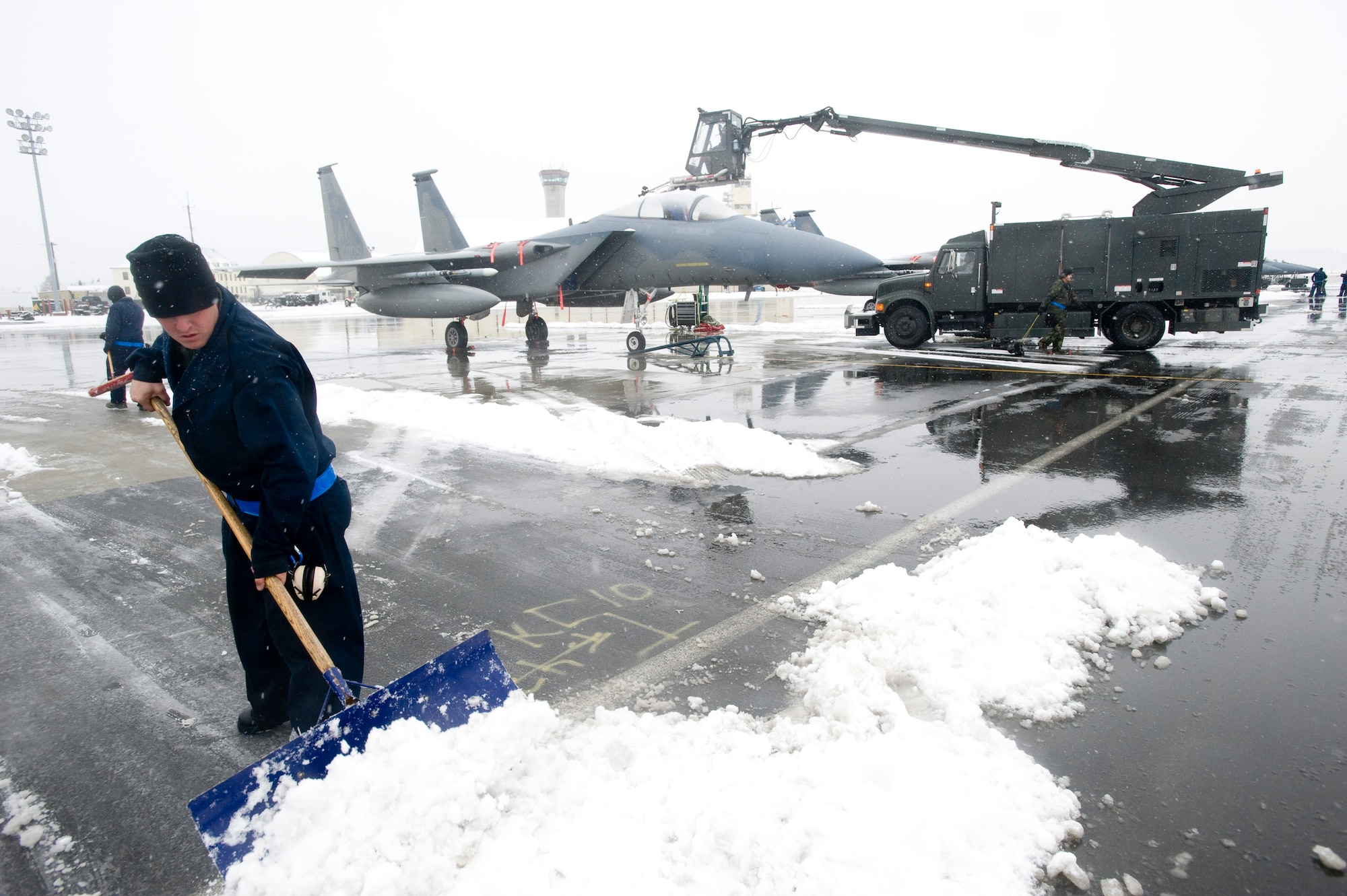 ELMENDORF AIR FORCE BASE, Alaska -- Staff Sgt. Mike Adams, 19th Aircraft Maintenance Unit, clears snow away from the aircraft Oct. 14. The 19th AMU maintains the F-15s in Alaska's extreme winter conditions. (U.S. Air Force photo/Senior Airman Jonathan Steffen)