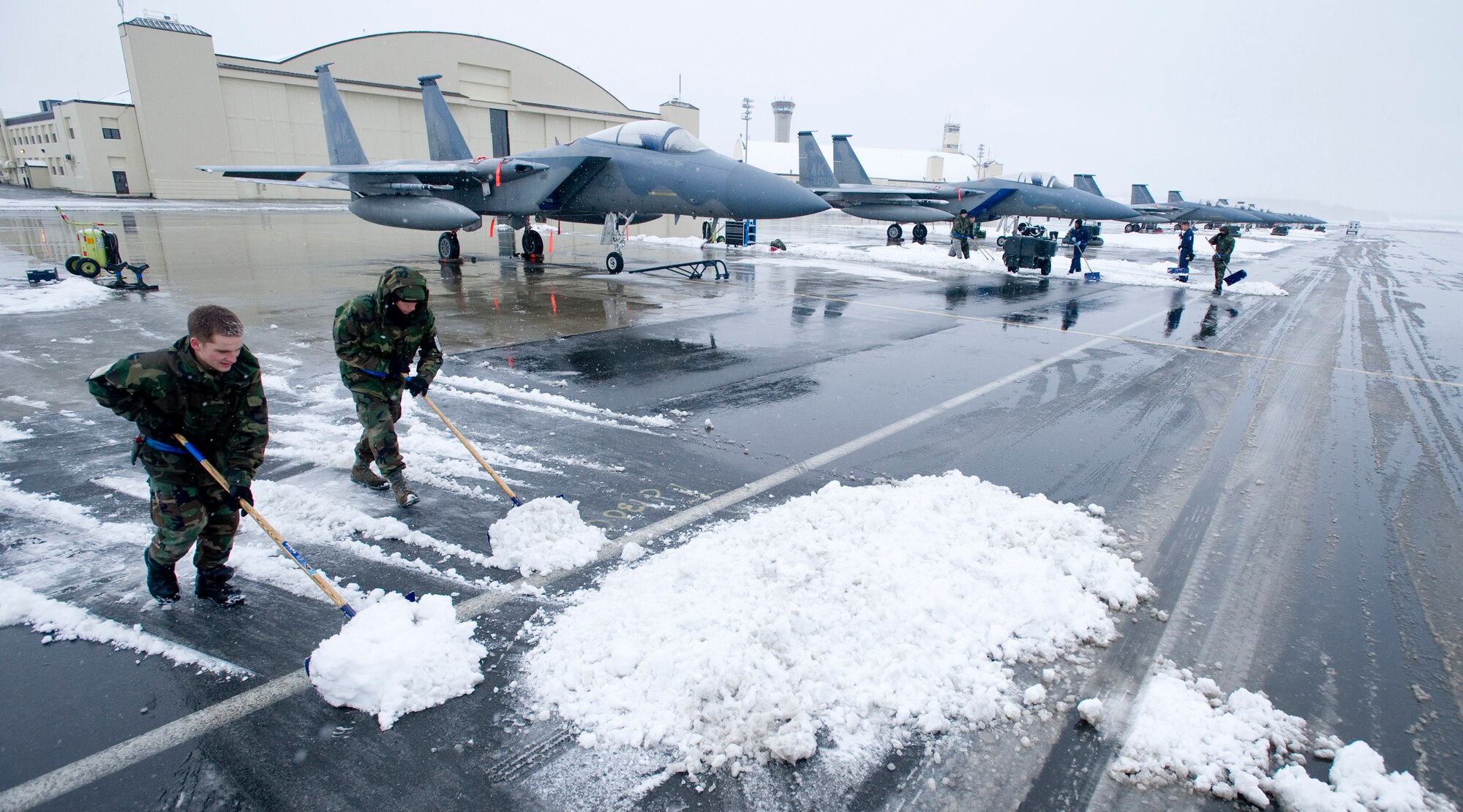 ELMENDORF AIR FORCE BASE, Alaska -- Airman 1st Class Sean Delaney and Airman 1st Class Kyle Lynn, 19th Aircraft Maintenance Unit, work together to plow snow off the flightline Oct. 14. The 19th AMU maintains the F-15s in Alaska's extreme winter conditions. (U.S. Air Force photo/Senior Airman Jonathan Steffen)