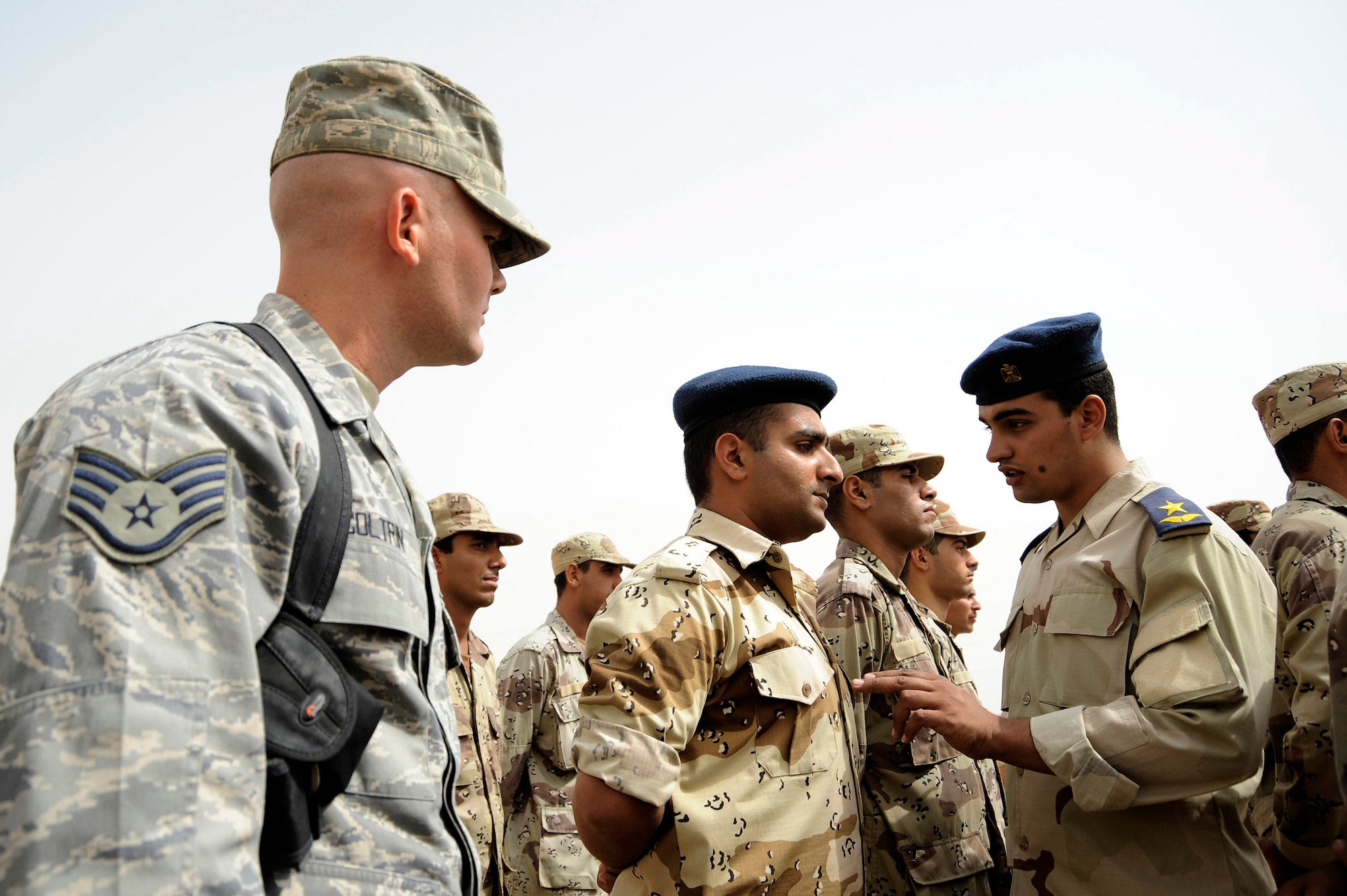 Staff Sgt. Matthew Coltrin (left) watches Iraqi air force Lt. Ali (right) explain the importance of military bearing to a warrant officer during parade practice Sept. 28 at Al Taji Air Base, Iraq. Sergeant Coltrin is a military training instructor air adviser with the 370th Expeditionary Training Squadron. Lieutenant Ali is an Iraqi military training instructor. (U.S. Air Force photo/Staff Sgt. Paul Villanueva II) 
