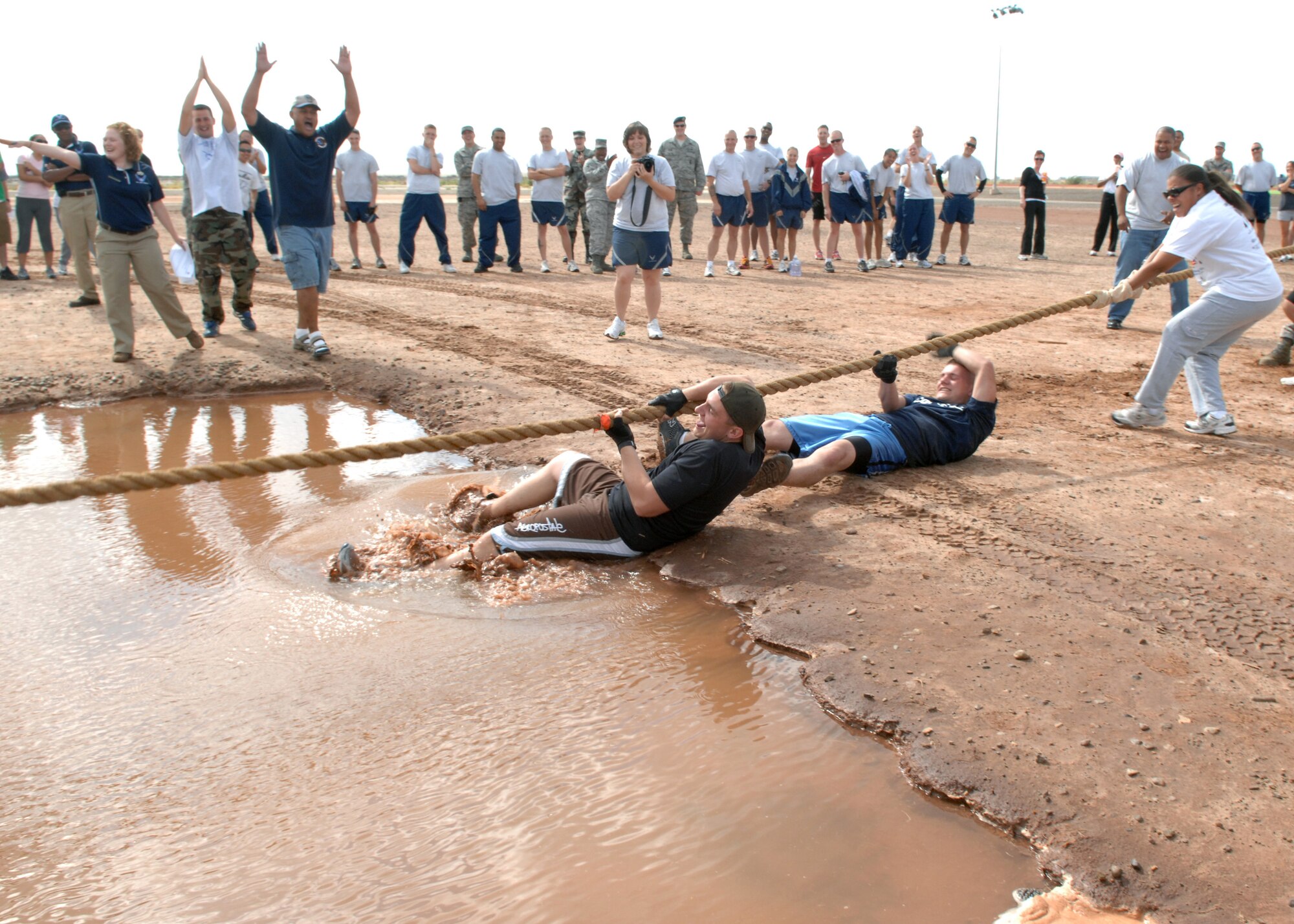 Team members from the 49th Logistic Readiness Squadron dive feet first into the muddy water, after losing in Tug-of-War at Holloman Air Force Base, N.M., October 10. Airmen from different squadrons, tested their strength at the Tug-of-War game during Sports day. (U.S. Air Force photo/Airman 1st Class Veronica Salgado)