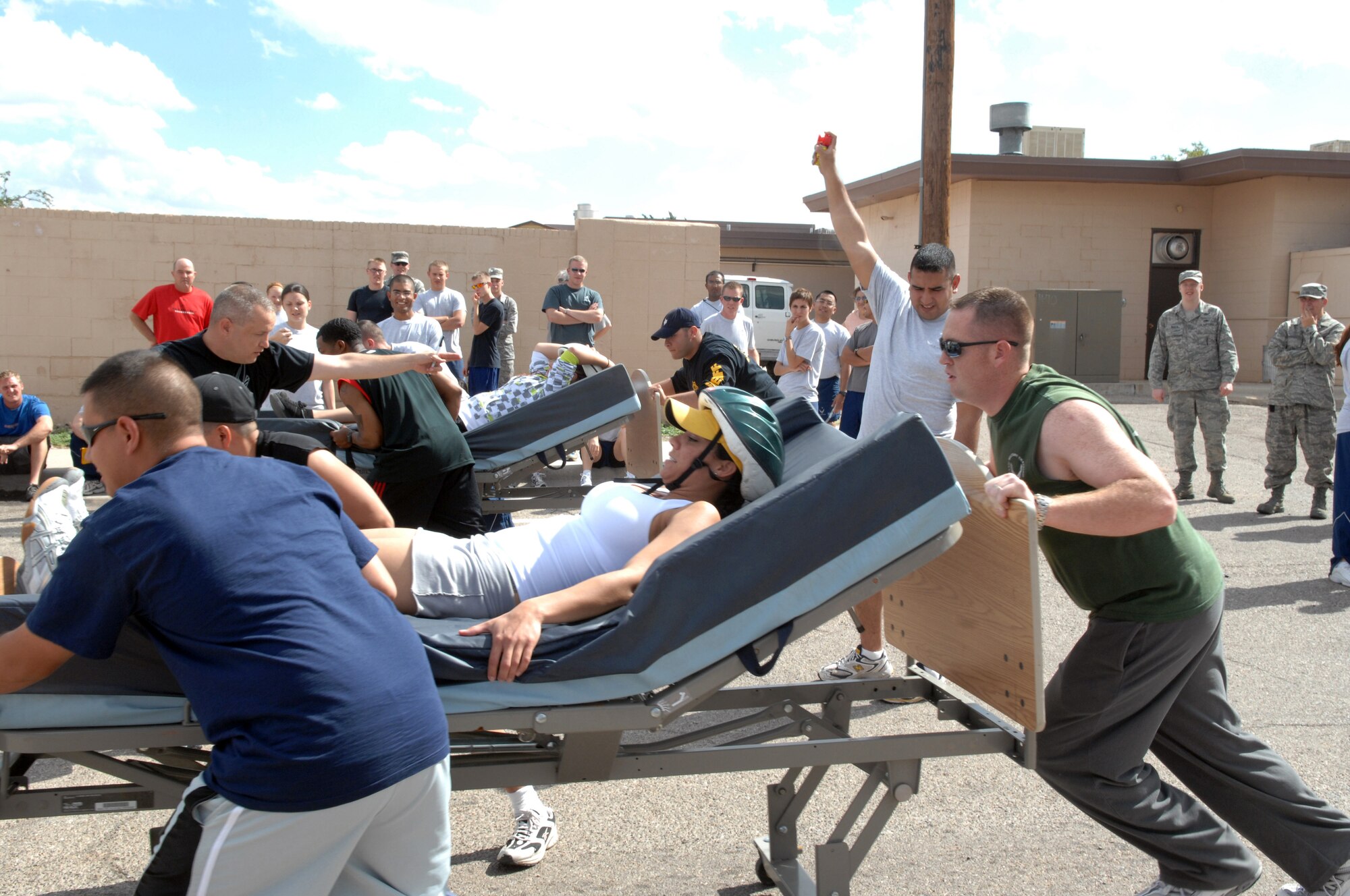 49th Materiel Maintenance Suppport Squadron team member, Airman 1st Class Bianca Rivera, holds on tight for a bed race against the 49th Security Forces team members at Holloman Air Force Base, N.M., October 10, during Sports Day. Staff Sgt. Noe Gutierrez sounds off the air horn for contestants to begin the race. (U.S. Air Force photo/Airman 1st Class Veronica Salgado) 