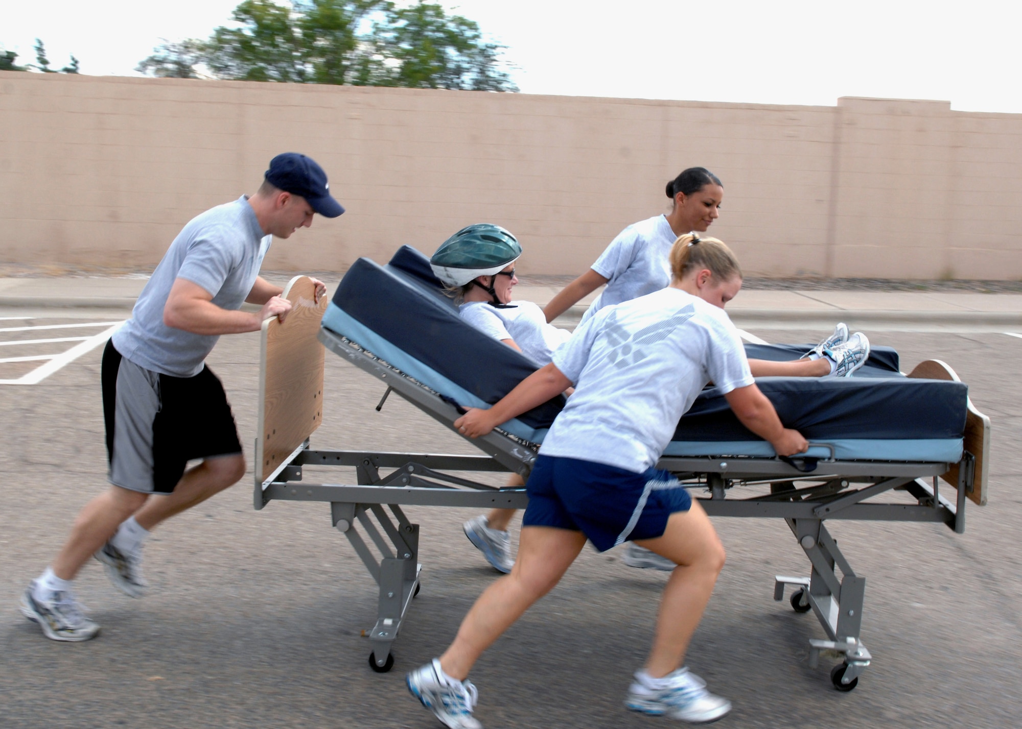 The 49th Aeromedical Dental Squadron team members push Tech. Sgt. Kristina Harper to the finish line during the bed race at Holloman Air Force Base, N.M., October 10. Airmen from all squadrons competed against one another in Sports Day. (U.S Air Force photo/Airman 1st Class Veronica Salgado) 
