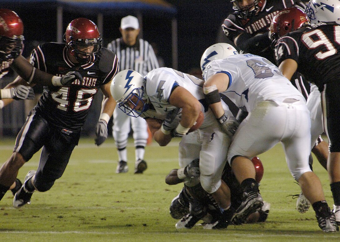 U.S. Air Force Academy Falcons fullback Todd Newell drags a tackler as he rushes for additional yardage Oct. 11 in a game against San Diego State in San Diego. Newell, a San Diego native and team captain, carried the ball 19 times for 77 yards and a touchdown in the Falcons' 35-10 win over San Diego State. (U.S. Air Force photo/Staff Sgt. Steve Grever) 