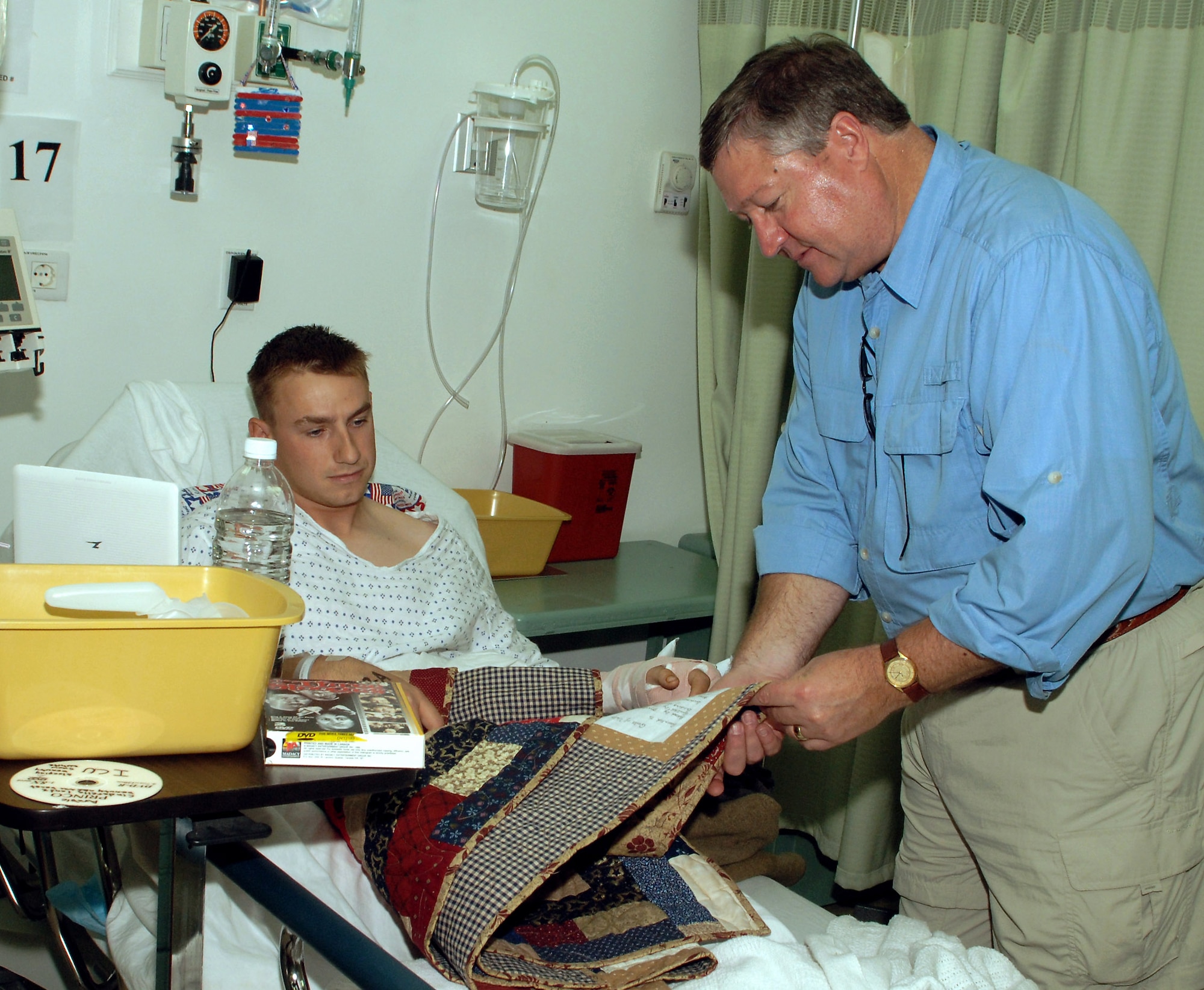 Secretary of the Air Force Michael B. Donley presents a quilt to Marine Cpl. Zhenya Killeen during a visit to the Air Force Theater Hospital Oct. 13 at Joint Base Balad, Iraq. Corporal Killeen was injured while trying to prevent damage to a snatch block on a wrecker truck. Surgeons could not save his ring finger but did save the rest of his hand. He is deployed to the 1st Battalion, 4th Marines Motor Transport Company, from Camp Pendleton, Calif. (U.S. Air Force photo/Tech. Sgt. Richard Lisum)
