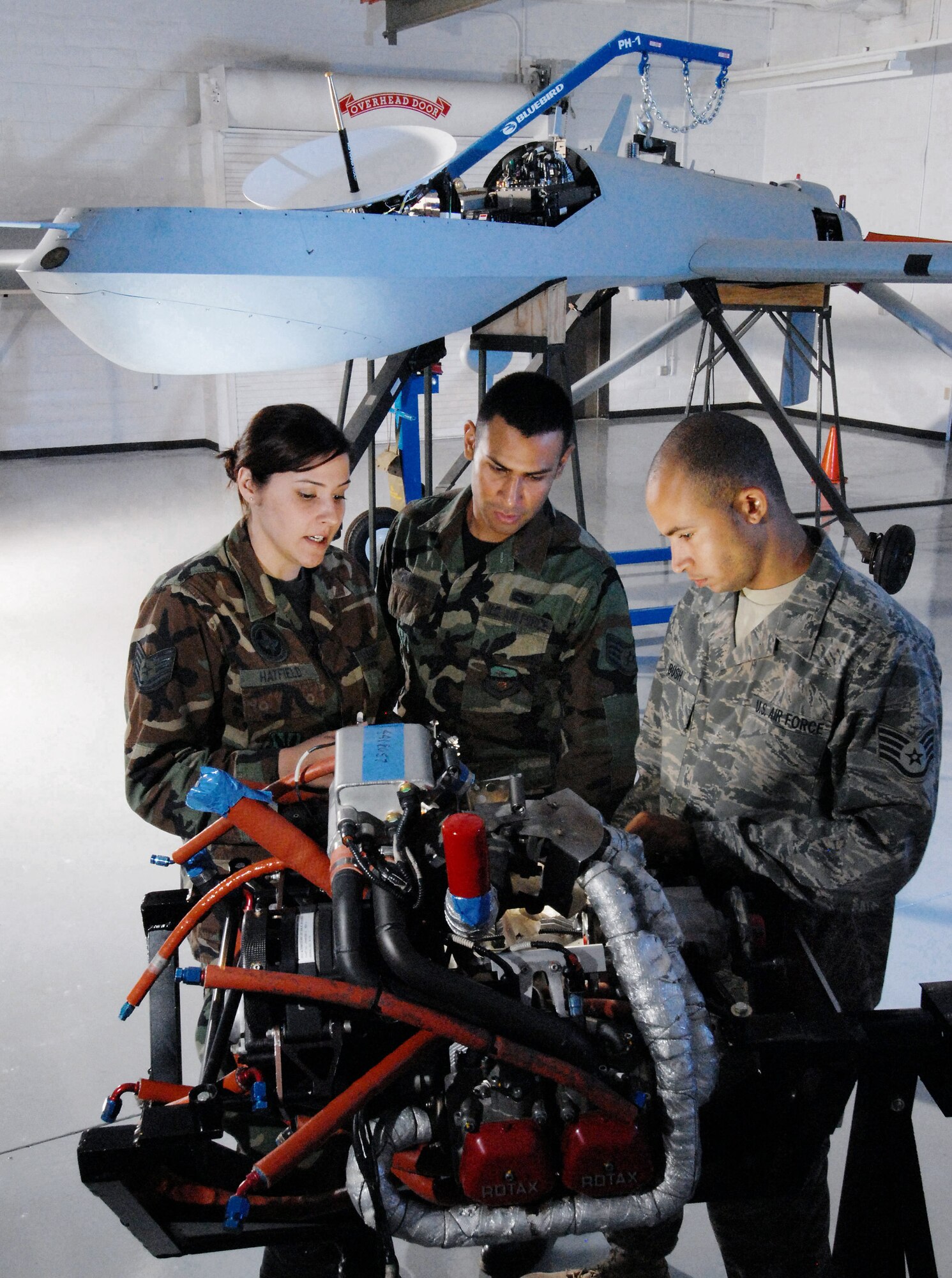 Tech. Sgt. Rebecca Hatfield (left), an instructor with Field Training Detachment 26 of the California Air National Guard's 163rd Maintenance Group, shows the components of the engine of an MQ-1 Predator unmanned aircraft to Staff Sgts. Carlos Barrera (center) and Alex Bush Oct. 15.  The two sergeants are crew chiefs with the 163rd Reconnaissance Wing at March Air Reserve Base, Calif.  Airmen with Det. 26 train active duty, Reserve and Air National Guard personnel on Predator maintenance operations. (U.S. Air Force photo/Val Gempis)