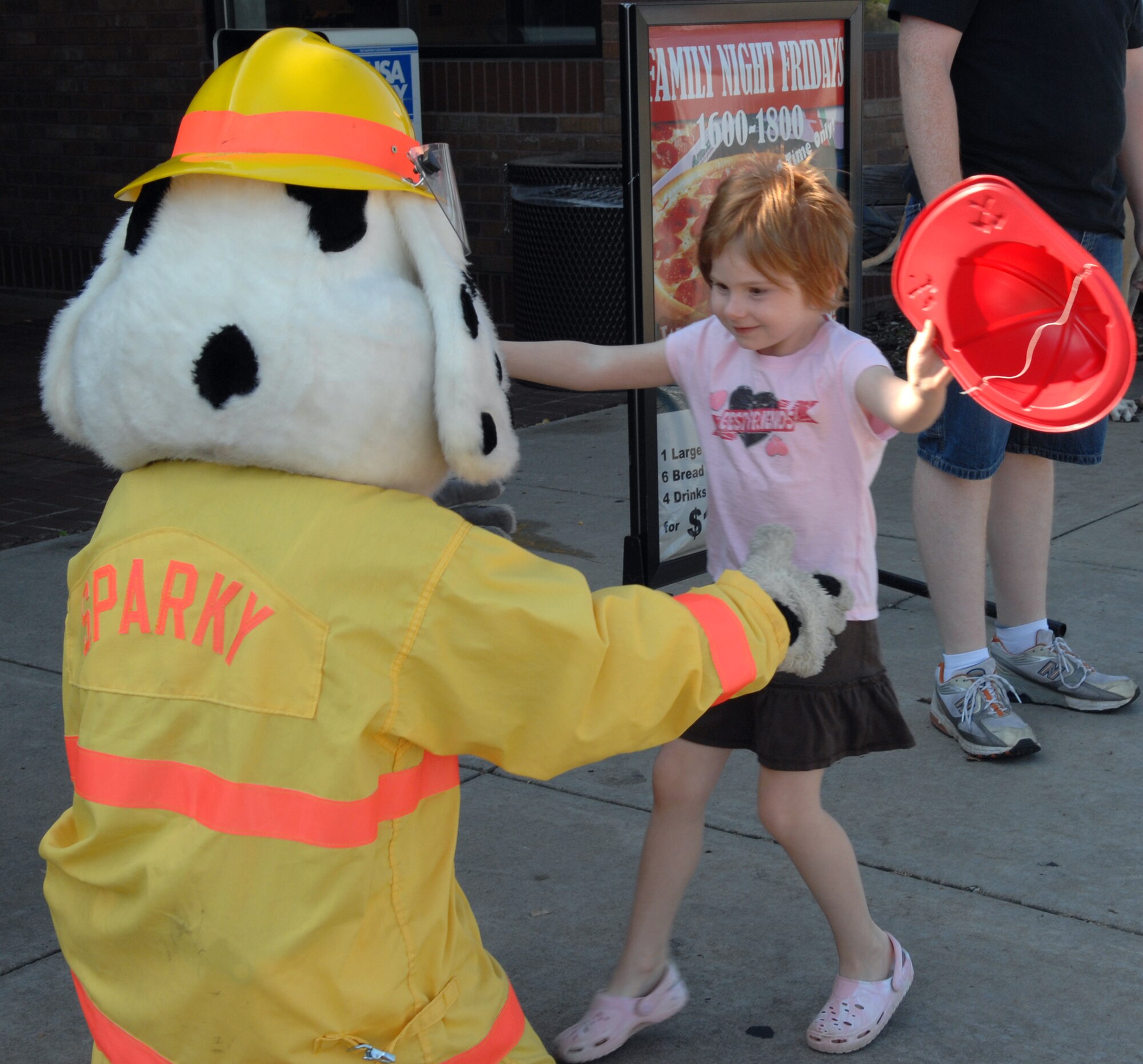 WHITEMAN AIR FORCE BASE, Mo. Sparky the fire dog gives Jordan Sondag, daughter of Stacey and Staff Sgt. Curtis Sondag, 509th Maintenance Squadron, a hug during Fire Prevention Week. Sparky and other members of the Whiteman Fire Department gave out fire safety products at the Base Exchange from 10a.m. to 2p.m. Oct. 11. (U.S. Air Force Photo/Senior Airman Stephen Linch) 