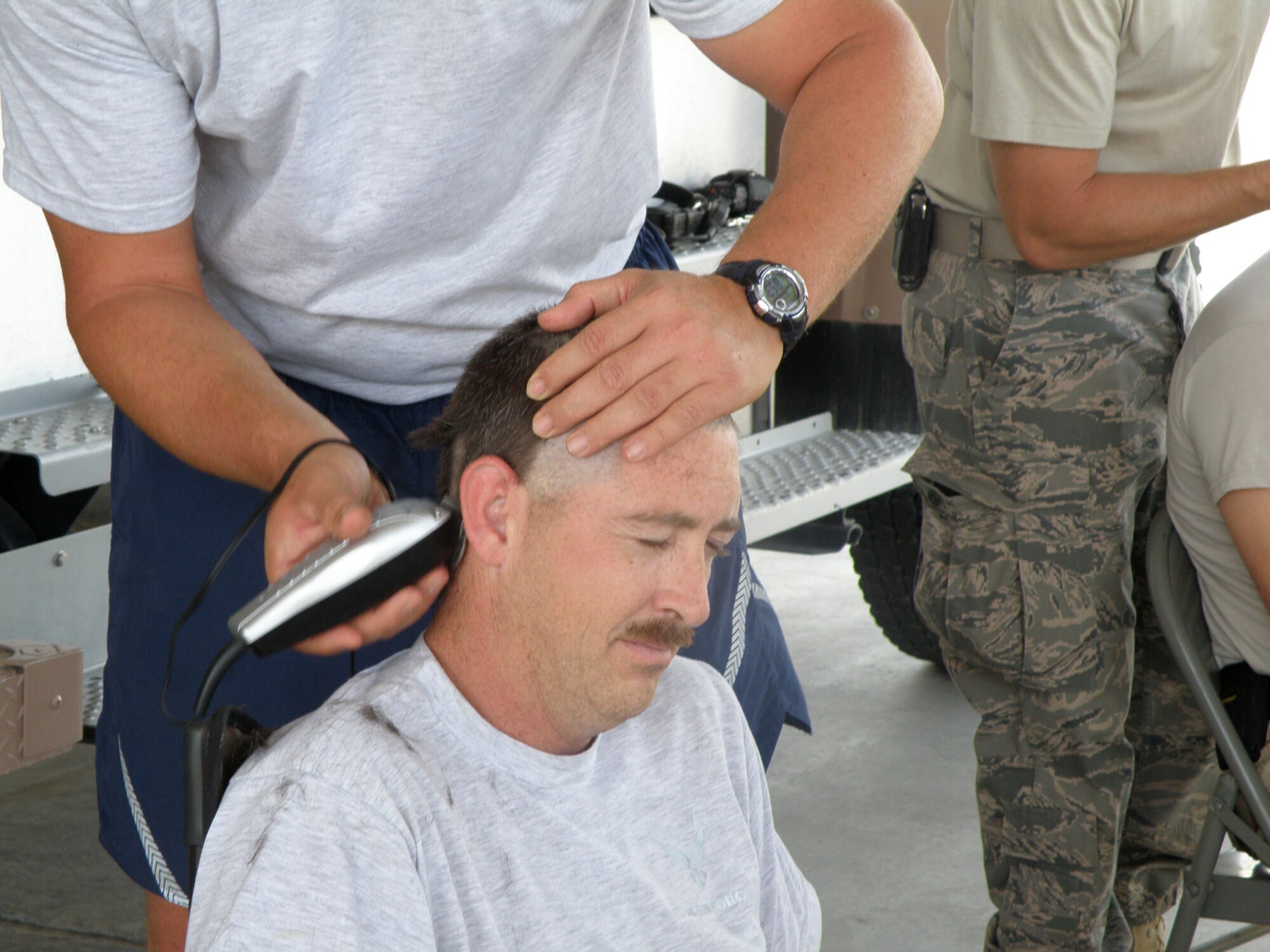 SOUTHWEST ASIA -- Col. Marcia Meeks-Eure, 386th Mission Support Group commander, prepares to cut the hair off Staff Sgt. Matt Tumelson, 386th Expeditionary Civil Engineer Squadron during the fundraising event “Operation Baldy Bash” Oct. 11 at a base in Southwest Asia. The fundraiser, which raised more than $500, will go towards education, training and awareness programs for families that have children with disabilities. 