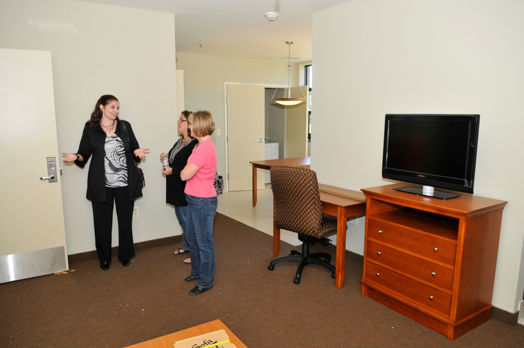 Ms. Kristin Ayyar, wife of Col. Balan Ayyar, 305th Wing commander, discusses the new temporary-living quarters during a spouses tour of the housing areas. The tour helped give the spouses indication of what the new houses will look like for Team McGuire members. (U.S. Air Force photo/Kenn Mann)