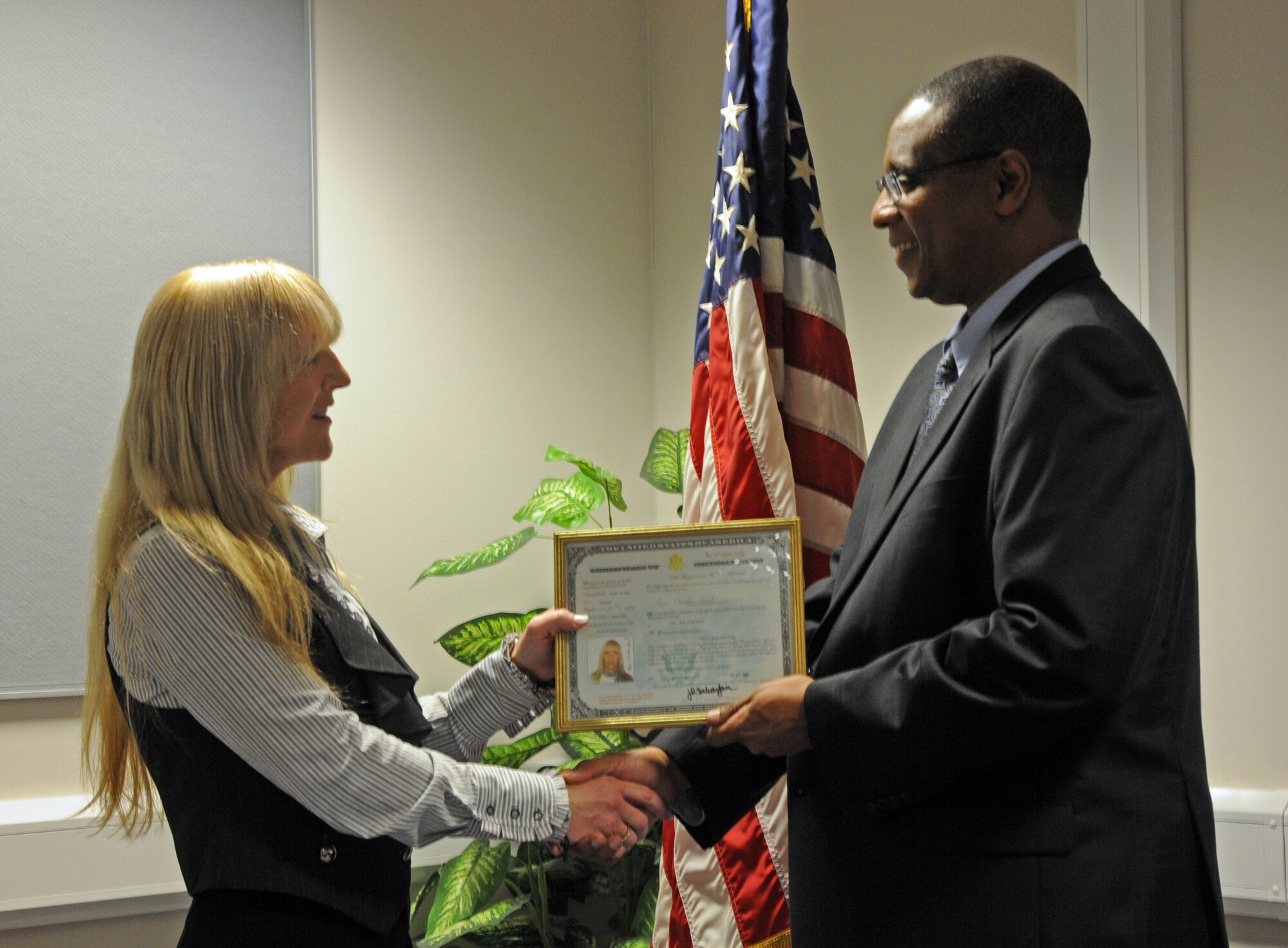 Lynn Ormesher-Imel, recieves her citizenship certificate from Elliott Cook, United States Citizenship and Immigration Services field office director, Oct. 11 at RAF Lakenheath, England. As of 2008, Ms. Ormesher-Imel is the first military spouse to be naturalized under section 319B Expedition Naturalization. Spouses of military members who are on orders overseas can file for naturalization if the spouse is a lawful permanent resident of that residing country and have at least 20 months left at their current overseas location. 