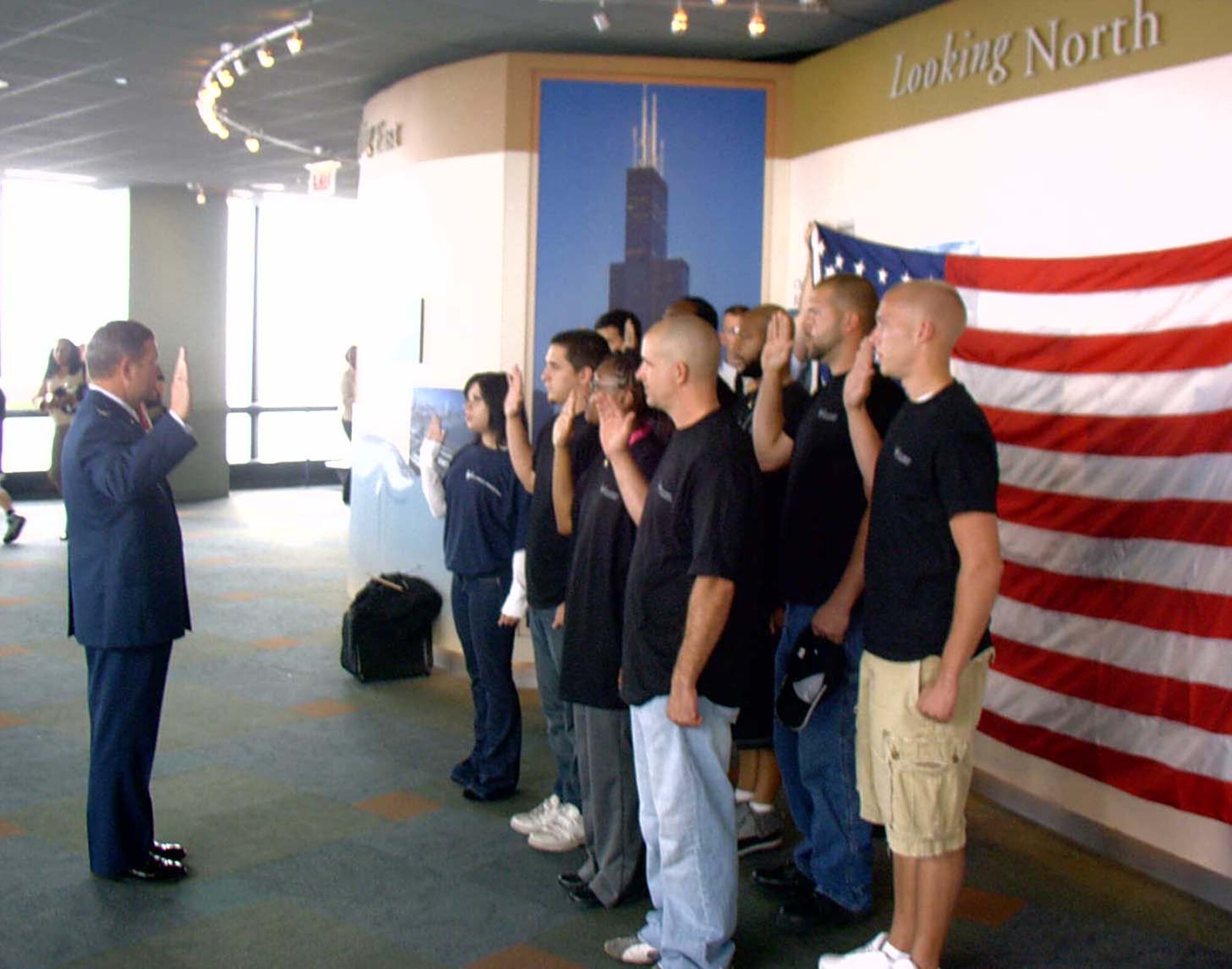 GRISSOM AIR RESERVE BASE, Ind., -- Col. Rick Maughmer (far left), Air Force Reserve Command Recruiting Squadron vice commander, administers the oath to nine new recruits during a mass enlistment ceremony at the Sears Tower in Chicago.  "We were able to go to the observation deck, hold our enlistment ceremony and have plenty of spectators on hand to see, even a Russian couple," said Senior Master Sgt. William Fountas, senior recruiter at Grissom.  "It was a great turn out from our applicants, their family and our recruiters."  Each year, the local recruiting squadron conducts a mass enlistment ceremony to kick off the new fiscal year.  (U.S. Air Force photo/Senior Master Sgt. William Fountas)