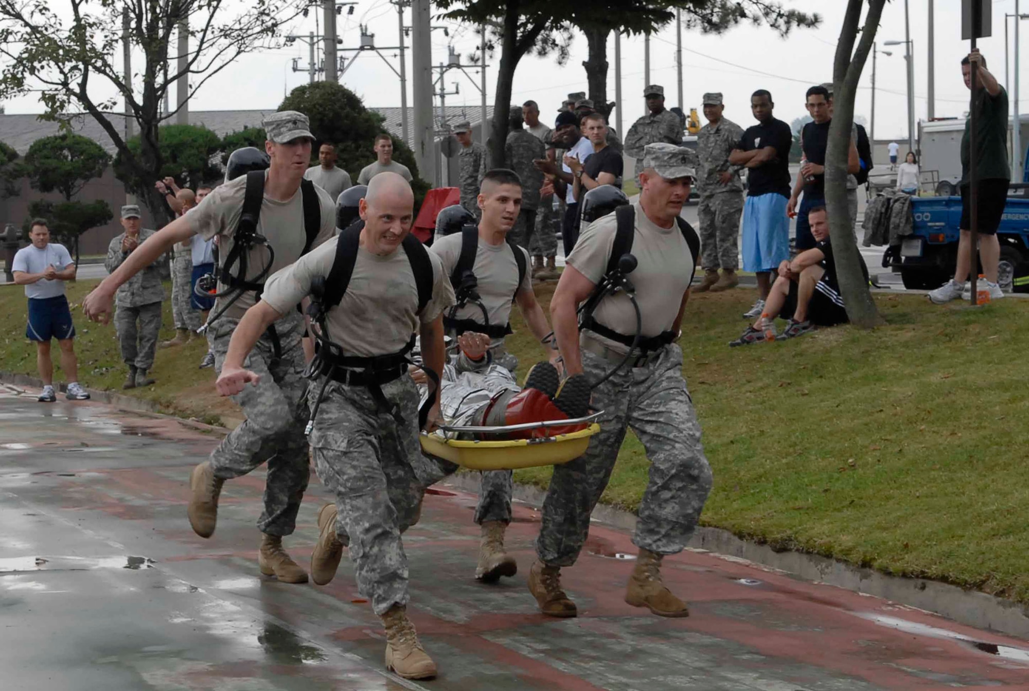 OSAN AIR BASE, Republic of Korea -- A team representing the 3rd Battlefield Coordination Detachment-Korea competes in the stretcher carry portion of the base's Firefighter Challenge Oct. 10 at the base fitness center. Five four-person teams competed in the challenge which also included a 100-foot weave with airpack, 100-foot stretcher carry, 100-foot hose carry and a 100-foot hose drag. The base fire department and fitness center co-hosted the event in recognition of National Fire Prevention Week. (U.S. Air Force photo/Staff Sgt. Scottie McCord)
