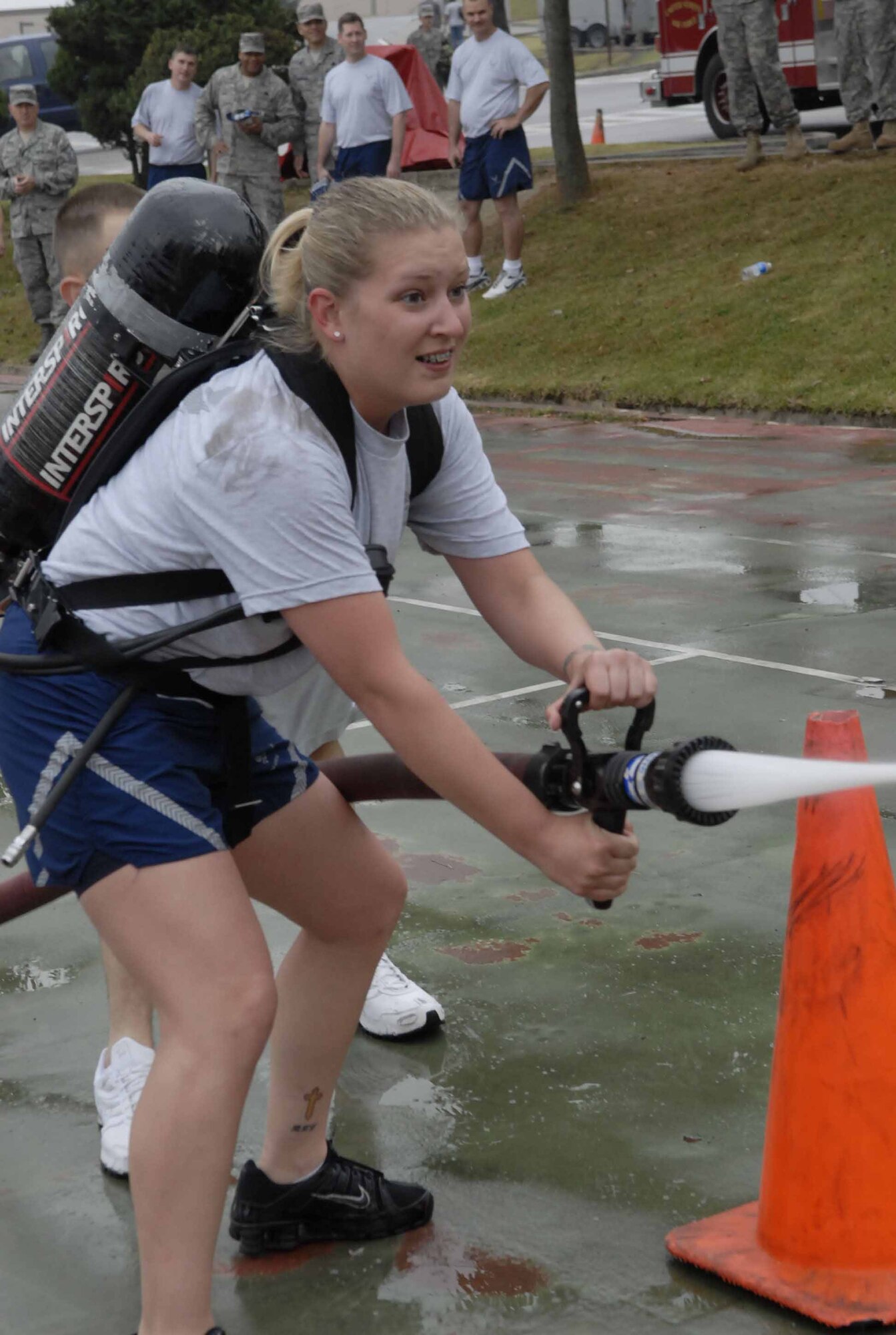 OSAN AIR BASE, Republic of Korea -- Staff Sgt. Heather Flanagan, 51st Security Forces, tries to knock a tennis ball off a traffic cone during the charged-line challenge portion of the base's Firefighter Challenge Oct.10 at the base fitness center. The base fire department and fitness center co-hosted the event in recognition of National Fire Prevention Week, Oct. 6 to 10. (U.S. Air Force photo/Staff Sgt. Scottie McCord)