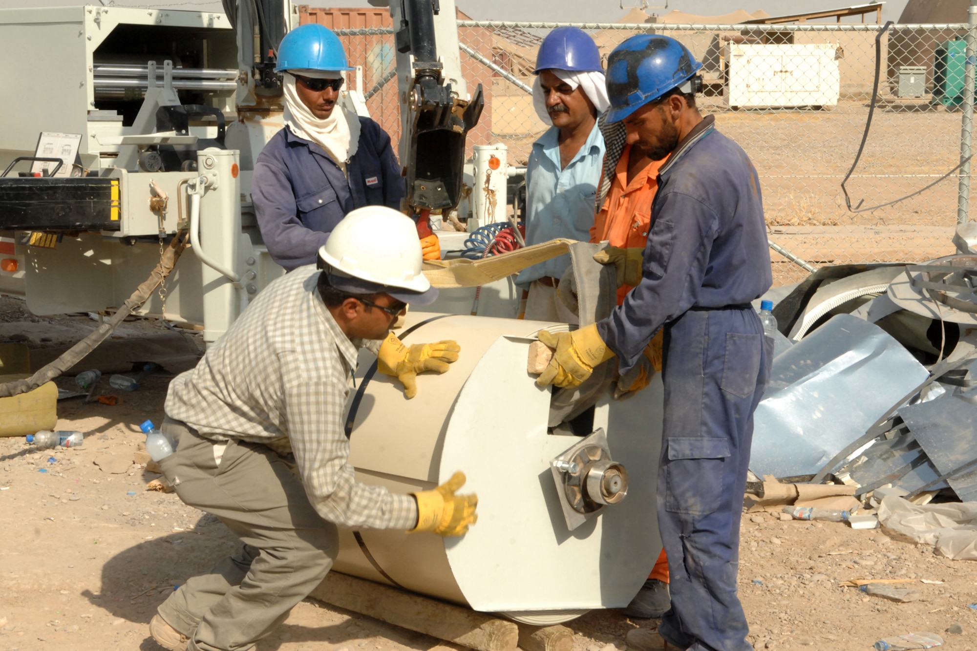 KIRKUK REGIONAL AIR BASE, Iraq ? Workers prepare to place a roll of metal into the Ultimate Bending Machine which forms the metal into shaped sections used for the construction of K-Spans buildings.  When completed at the end of the year, the building will be part of a $30 million complex, which will include 24 buildings and support 880 Iraqi air force personnel. (U.S. Air Force photo/Senior Airman Randi Flaugh)