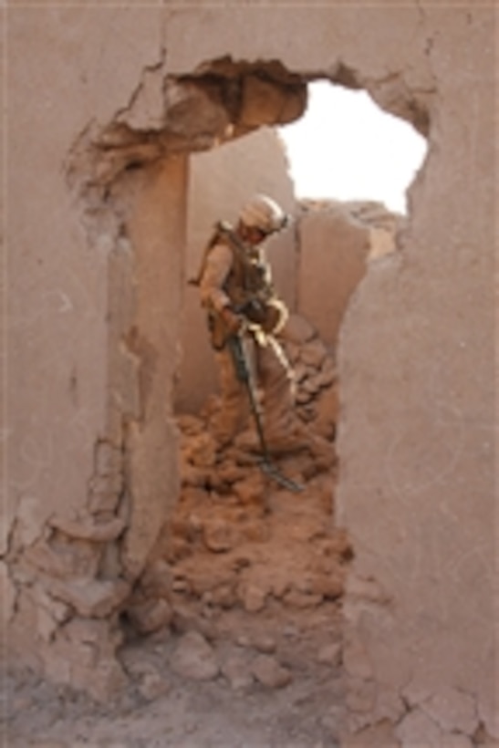 U.S. Marine Corps Sgt. Vince Mabalot, assigned to a personal security detail with Regimental Combat Team 5, uses a metal detector to search an abandoned structure during an operation north of Al Qaim, Iraq, on Oct. 6, 2008.  The operation is designed to prevent smuggling between Syria and Iraq.  