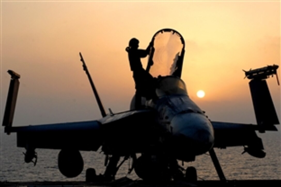 U.S. Navy Petty Officer 3rd Class Kyle Alhers performs his morning routine on an F/A-18C Hornet aboard the aircraft carrier USS Ronald Reagan in the Gulf of Oman, Oct. 14, 2008. 