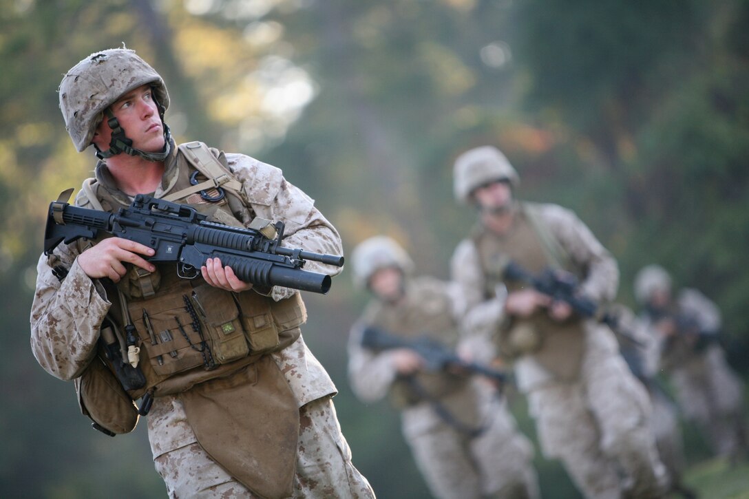 Cpl. Dan Clark, a field military policeman from MP Company, Combat Logistics Regiment 27, 2nd Marine Logistics Group, patrols with fellow Marines along a fence line during combined pre-deployment training at 2nd MLG's Battle Skills Training School, here, Oct. 15. Clark, a native of Quincy, Mass., understands another element of pre-deployment training that is often overlooked in Marine units, which is to handle personal, practical, financial and legal issues that affect all individual Marines.