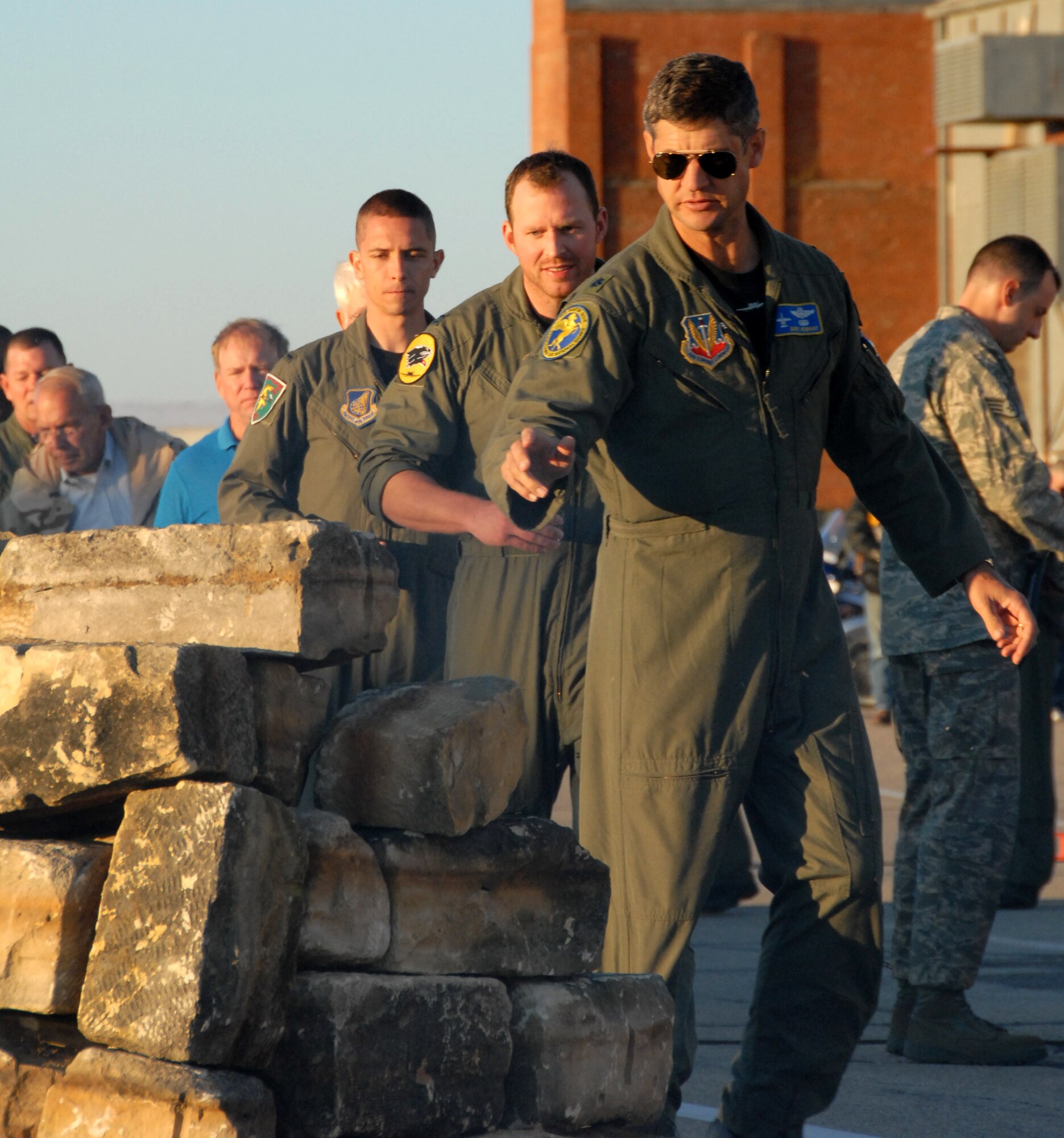 Lt. Col. Daryl Newhart, an A-10 pilot with the Pennsylvania Air National Guard's 103rd Fighter Squadron, throws a shot glass into a fire pit during a "Lost Hogs" memorial ceremony Oct. 15, at Hawgsmoke 2008, at the Salina, Kan., airport.  Hawgsmoke is a bienniel A-10 aerial gunnery and bombing competition. The Lost Hogs ceremony pays homage to all A-10 pilots who have passed away. In an A-10 tradition, pilots drink a shot as a toast to their fallen comrades then throw the shot glass into a fire pit after the names of all deceased A-10 pilots have been read aloud. (U.S. Air Force photo/Maj. David Kurle)