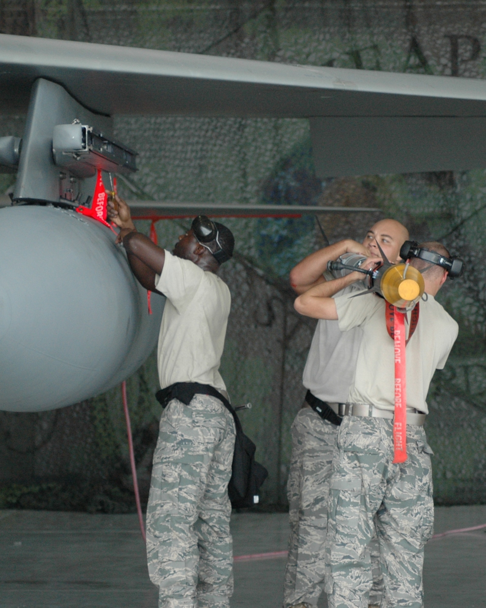 The team selected by leadership to represent the 60th AMU, Staff Sgt. Robert Constant, Senior Airman DeJuan Hazel and Airman 1st Class Matthew Jones, load an AIM-9X onto an LAU-128 Launcher on station 2A of an F-15 Eagle. The team took top honors during the Oct. 10 quarterly weapons load competition at the 33rd Fighter Wing. (U.S. Air Force Photo/Chrissy Cuttita)